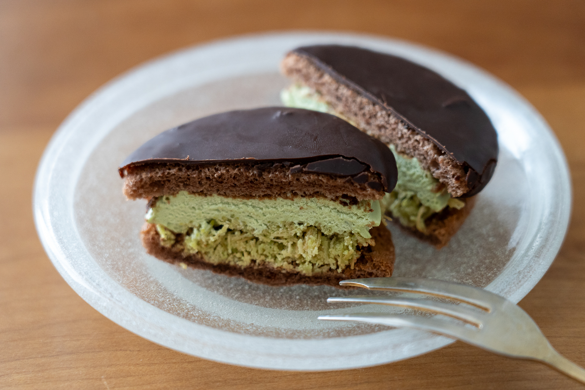 コーティングされた艶やかなチョコブッセの間に、淡いグリーンのピスタチオペーストと、サクサクとしたカダイフの生地がたっぷり
