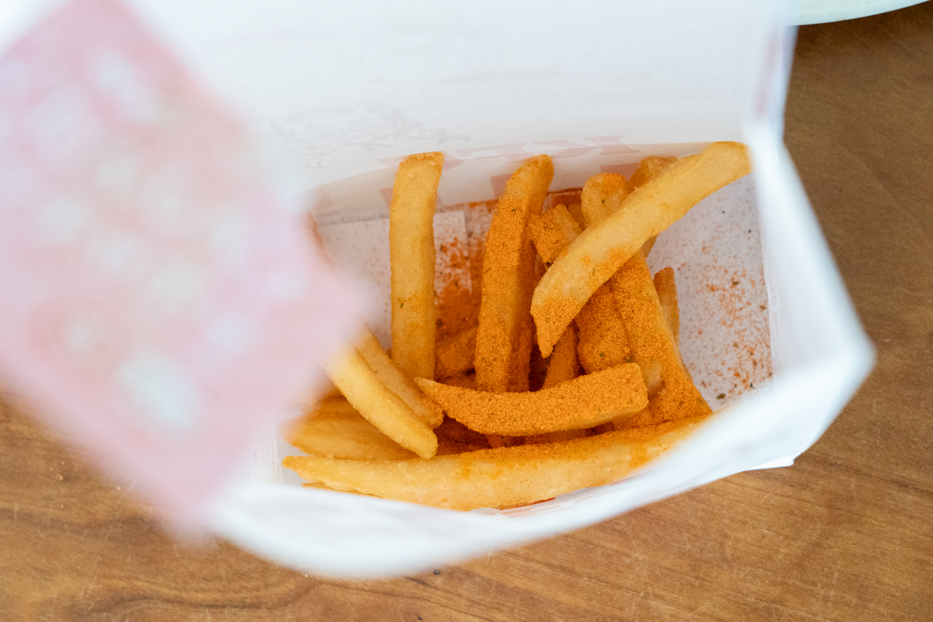 フリフリ袋の中にポテトを入れ、その上から「にんじんオッチャホイフリフリスパイス」を投入してシャカシャカ