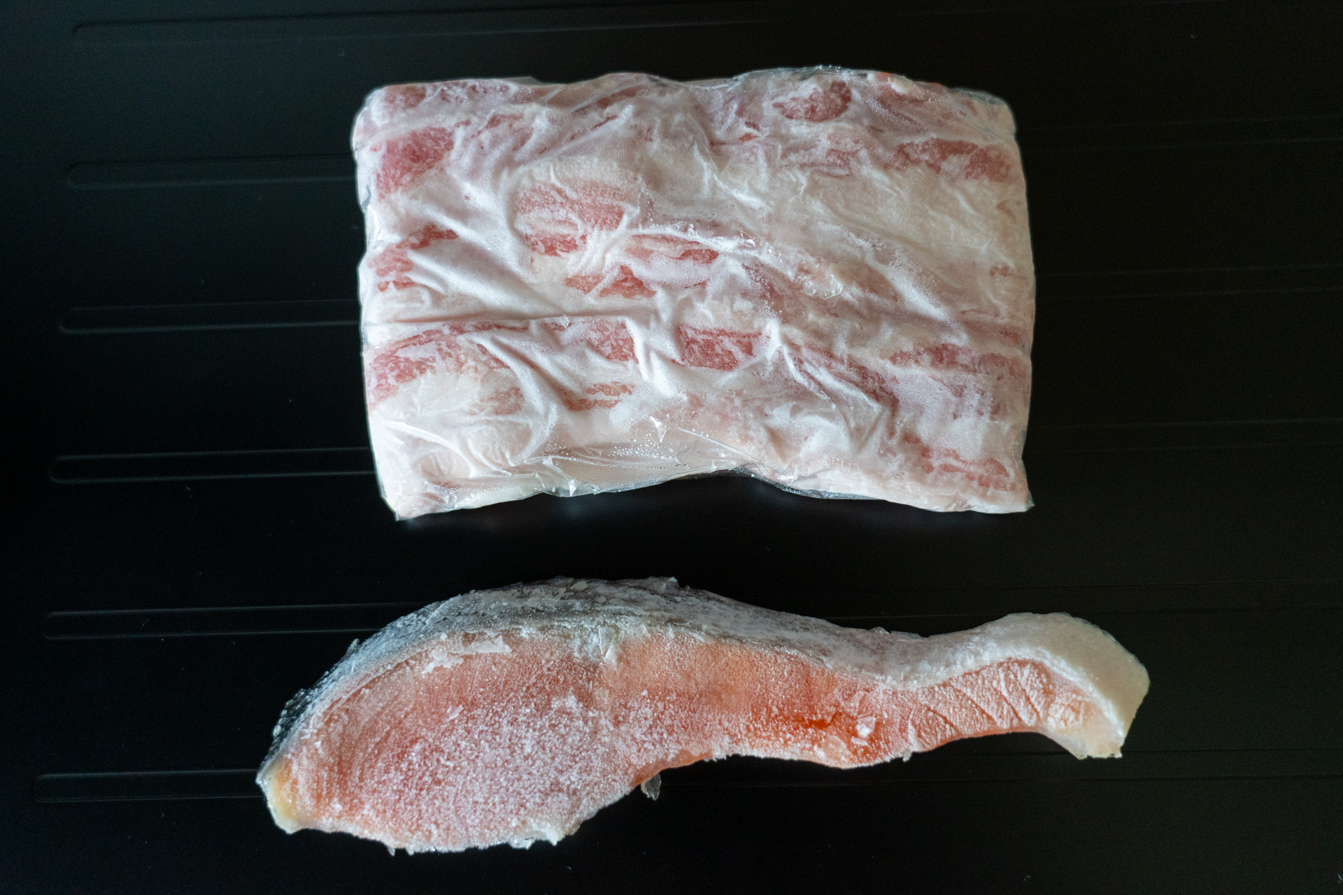 左が解凍プレート付きまな板、右が普通のまな板。どちらの鮭・豚肉も冷凍庫から出したカチカチ状態