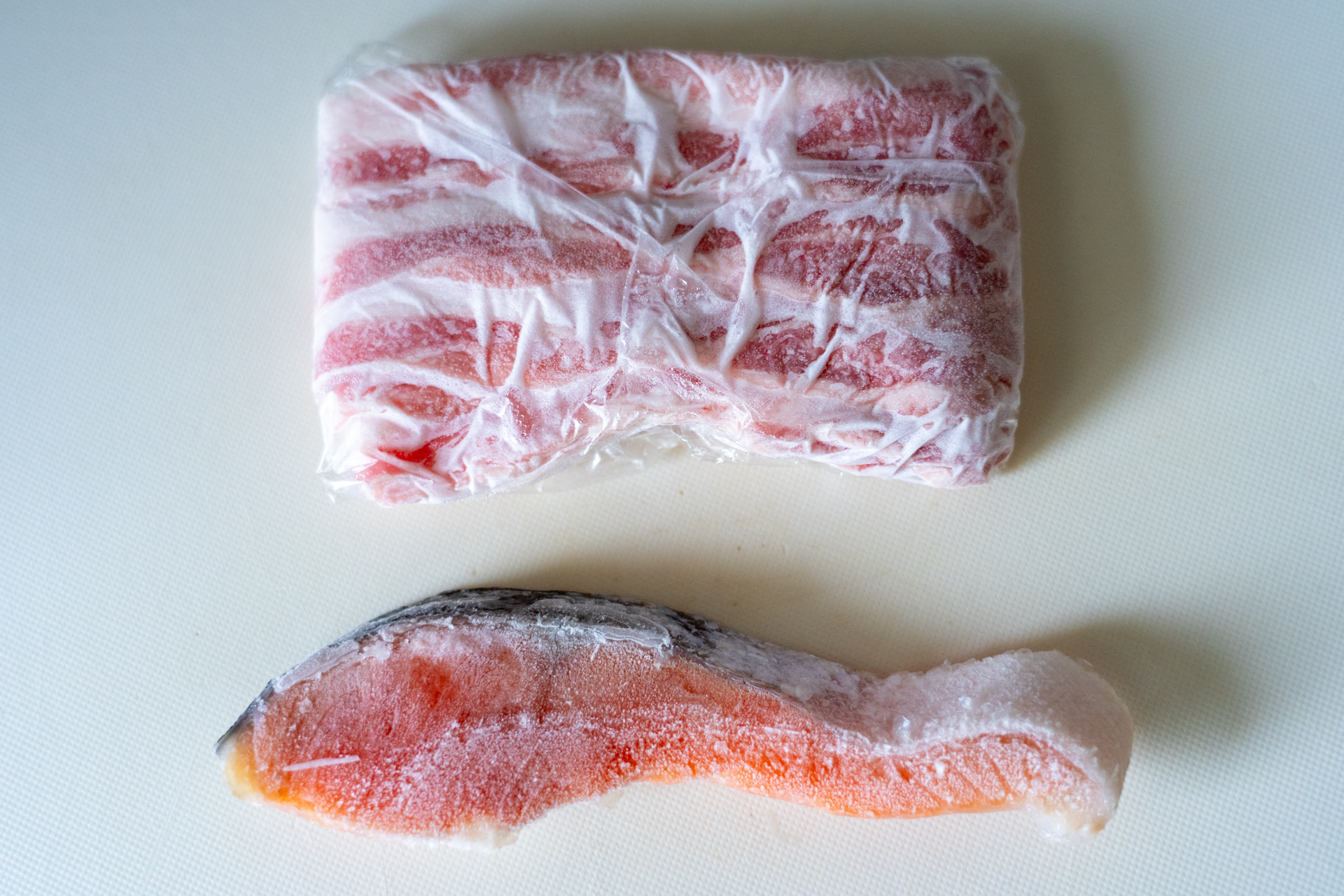 左が解凍プレート付きまな板、右が普通のまな板。どちらの鮭・豚肉も冷凍庫から出したカチカチ状態