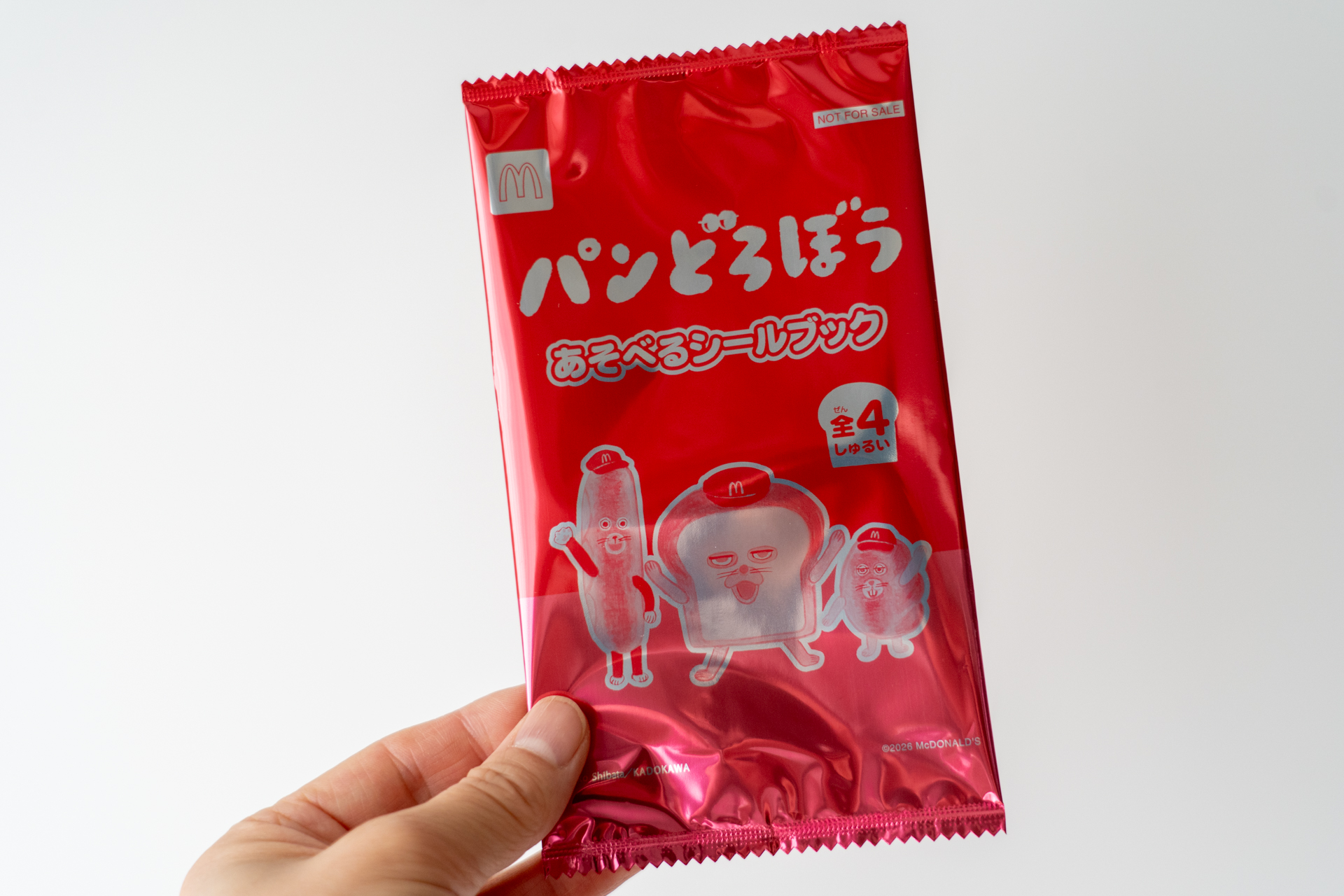 パンどろぼうの「あそべるシールブック」が入ったパッケージには、マクドナルドのバイザーを被ったキャラクターたちがデザインされている