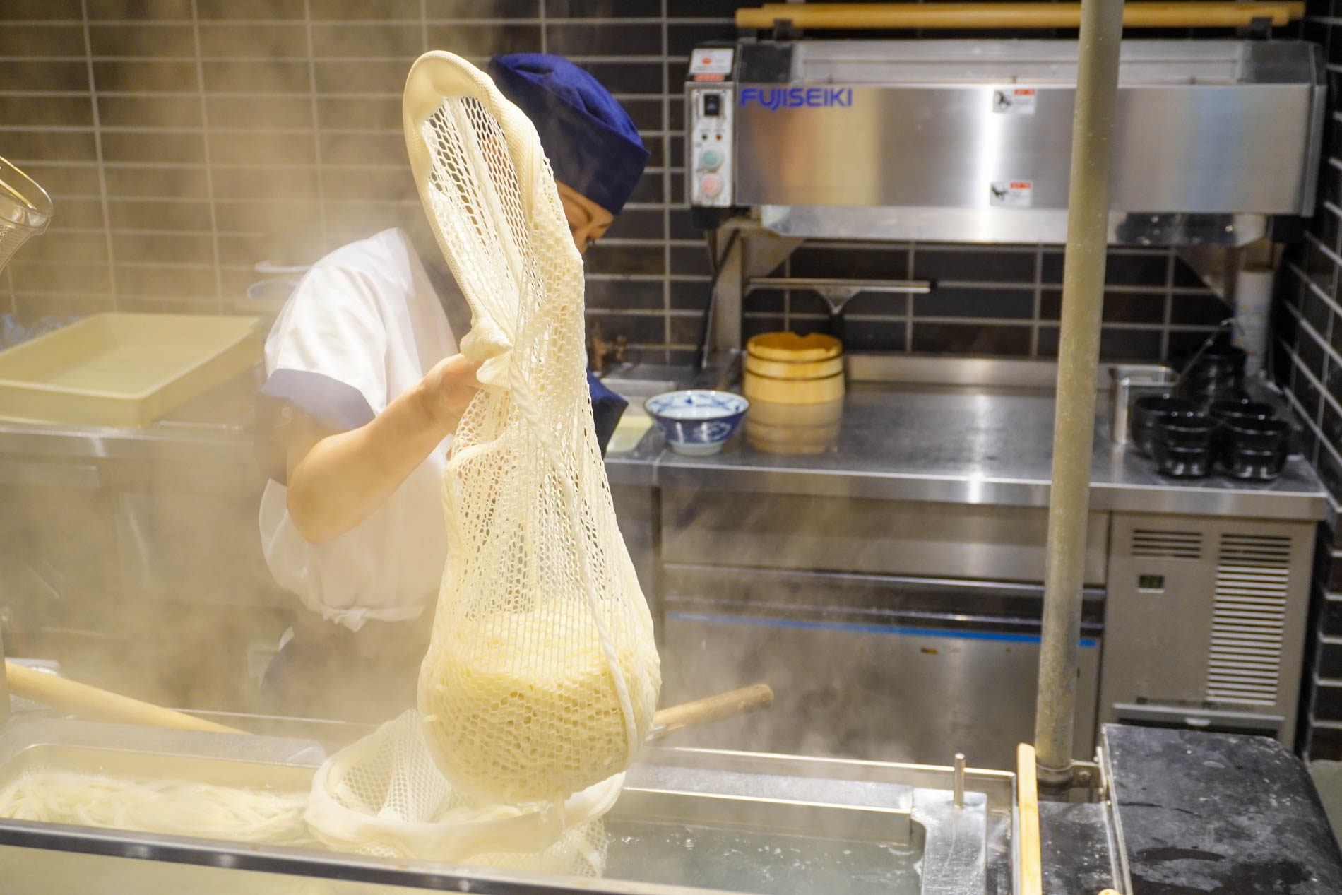 さらに茹でた後、締めた麺用の麺を引き上げる