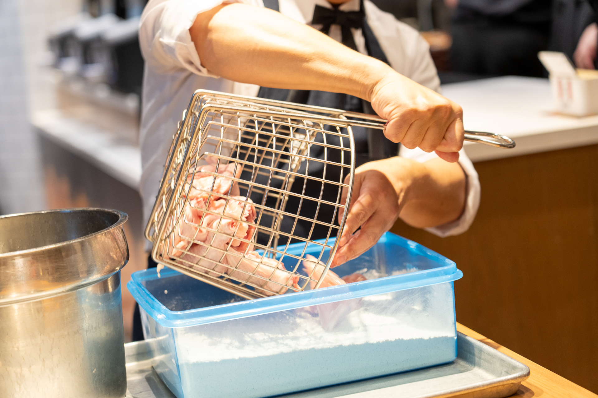 適度につなぎ液を落とした鶏肉を粉に入れ、粉がまんべんなくつくようによくまぶす