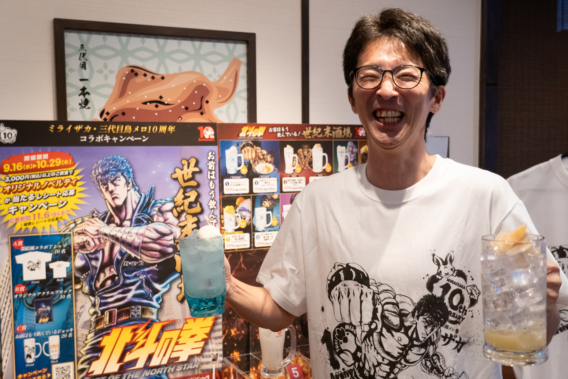 北斗の拳の10周年Tシャツを着たワタミ株式会社 マーケティング本部 外食販促企画部 部長の寺西氏とコラボドリンク