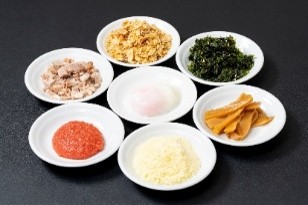 リニューアルオープンにあわせて新たに「辛味ダレ」「温泉たまご」「フライドオニオン」「韓国のり」「メンマ」「パルメザンチーズ」「明太子」「ネギ」「コマチャ」「ネギ塩」といったトッピングに加え、「ケイジャン」「カレー粉」「魚粉」「青さのり」4つの調味料が加わり、油そばを自分好みのおいしさで楽しめる