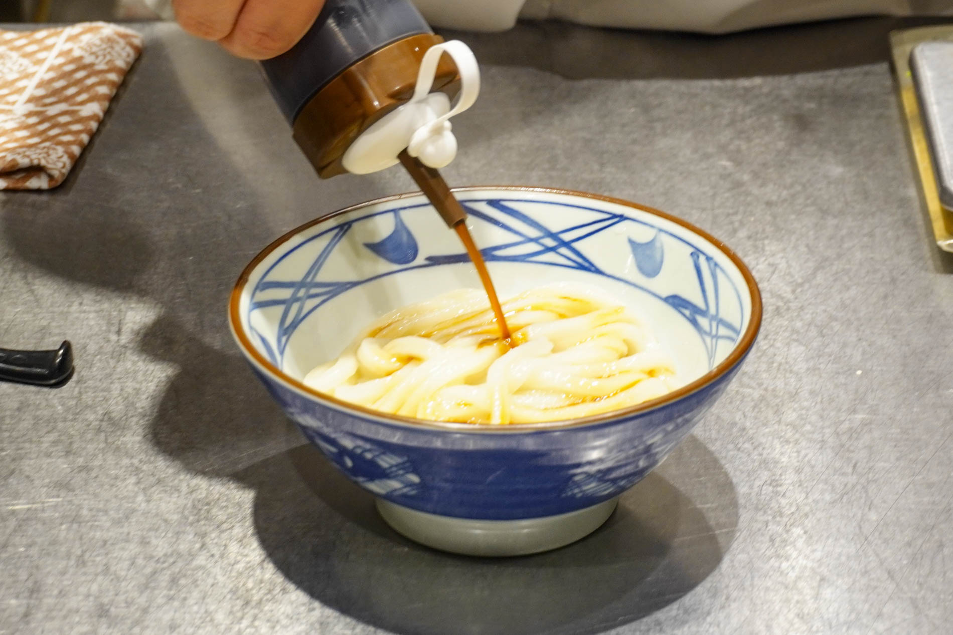 調理工程。釜抜き麺にかえしをかける