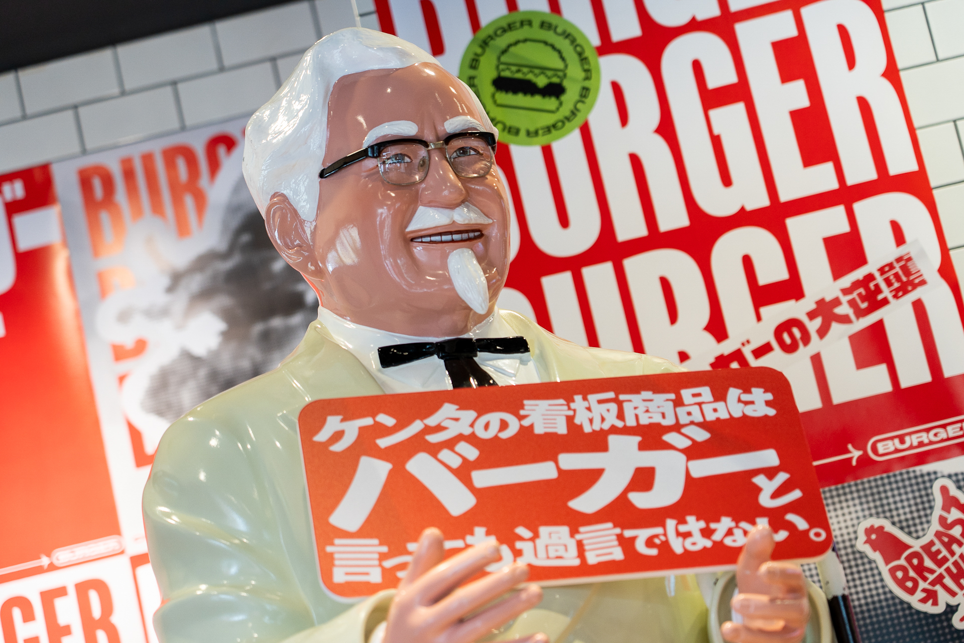 会場ではカーネル・サンダース像が「ケンタの看板商品はバーガーと言っても過言ではない」のボードでお出迎え