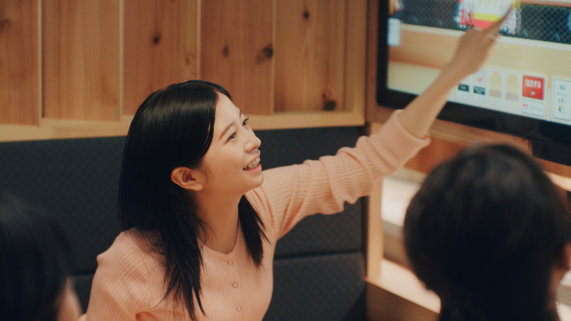 TV-CMのワンシーン「桜田さんがパネルをタッチする様子」