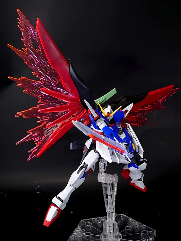 完成した「HGCE 1/144 デスティニーガンダム」を、別売りのアクションベースにディスプレイしました。冒頭で紹介したように、ボディの可働によってグッと力のこもったポージングが可能です。光の翼が同梱されているなど、内容物もお得なキットと言えましょう。誰でも作れるのにこのかっこよさ！　いいですね！