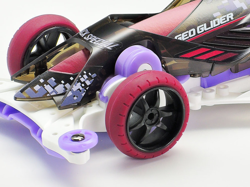 ブラックのVスポークホイールはカーボン強化タイプ。マルーンの<a href="https://www.tamiya.com/japan/products/95482/index.html" class="n" target="_blank">ローフリクション大径ナローバレルタイヤ</a>は、グリップを抑えてシャープなコーナリングを実現