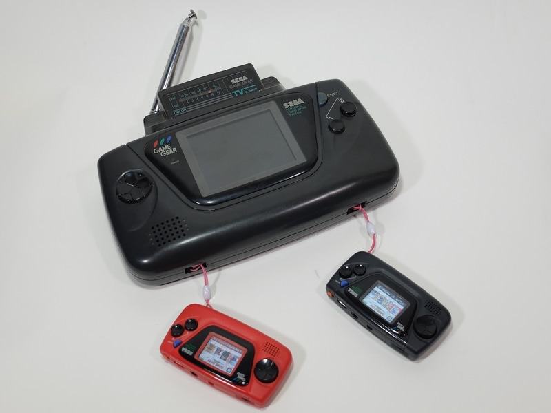 巨大なゲームギアのストラップとして小さな「ゲームギアミクロ」を2台装着。完動品のゲームギアをお持ちの方は、是非このスタイルであえてオリジナルのゲームギアでゲームをプレイしてみてほしい