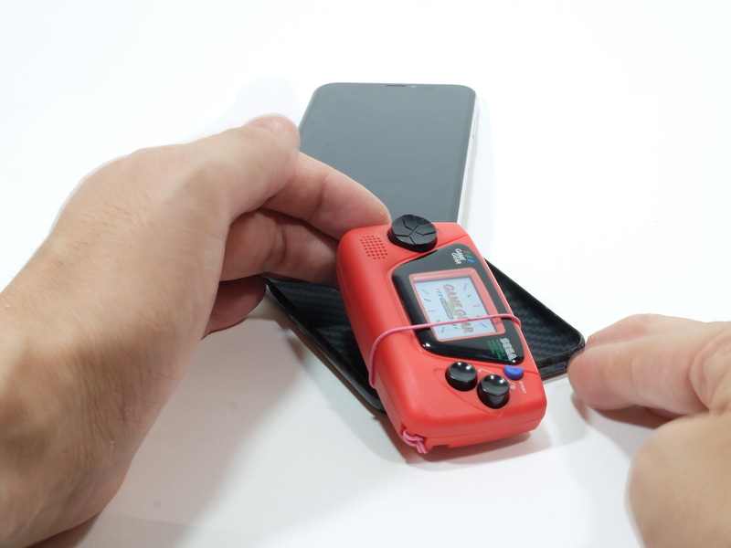 携帯ケースのスピーカーホールを利用して、そこにストラップを巻き付ける感じで装着する