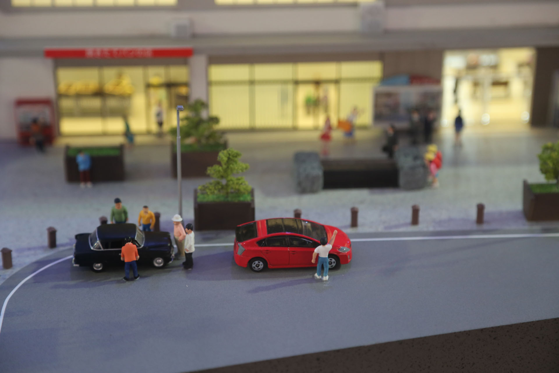 伊予西条駅の朝　クルマで見送る人たち　奥の赤い店舗はパン屋さんで、アンパンマン形のあんパンを売っていた。残念ながら現在は閉店している