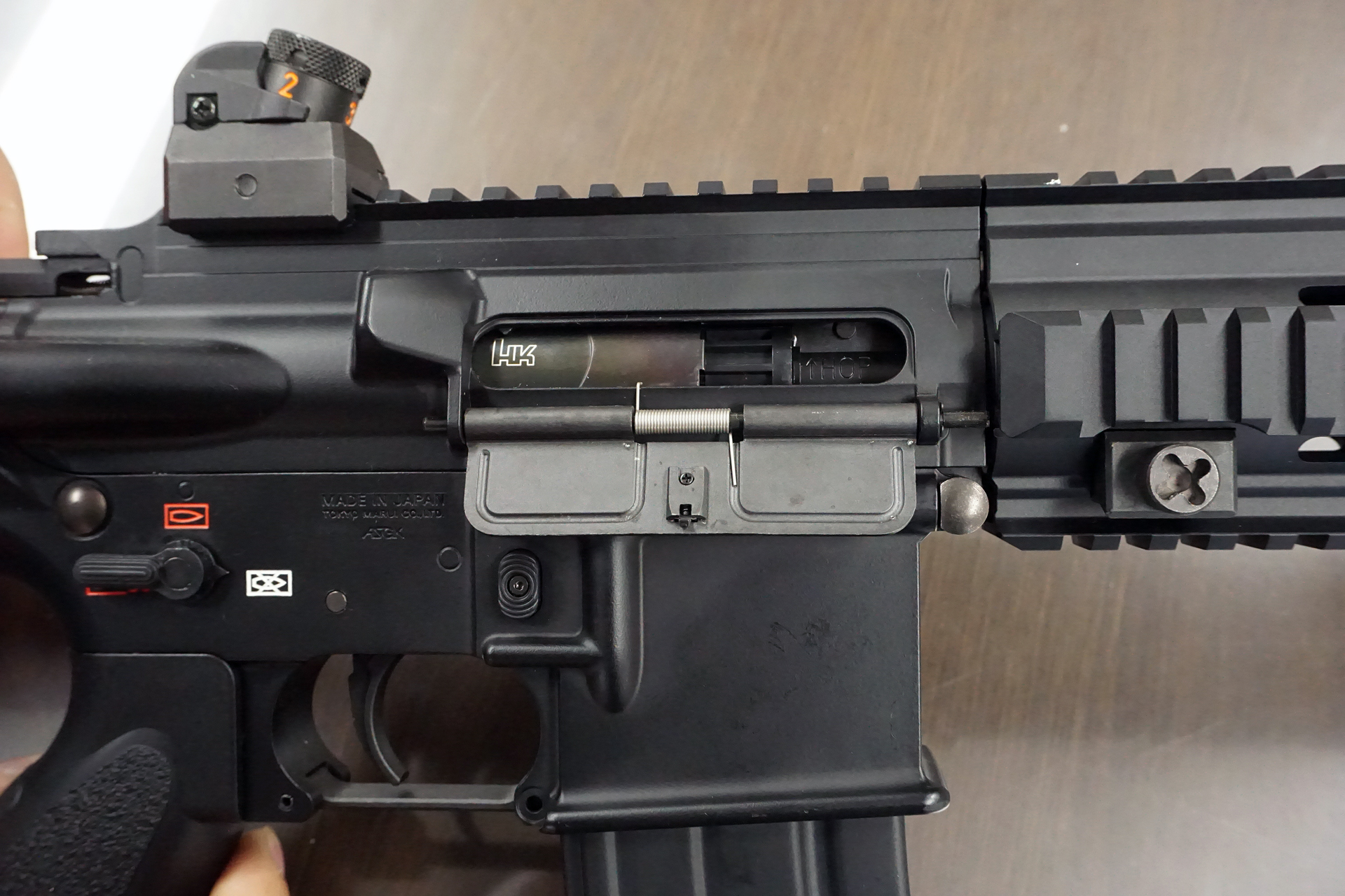 チャージングハンドルを引くとボルトを模したカバーが下がって弾道の調整（ホップ調整）が簡単にできるのは電動ガンの特徴