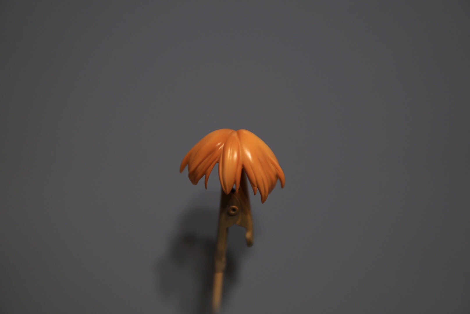 髪の毛の仕上げ色としてガイアノーツの「NAZCAシリーズ　マンダリンオレンジ」を塗っていきます。この時、一度に色を入れてしまうと影の色が消えてしまうため、遠くから薄く吹き重ねていき全体の色味を整えていきます