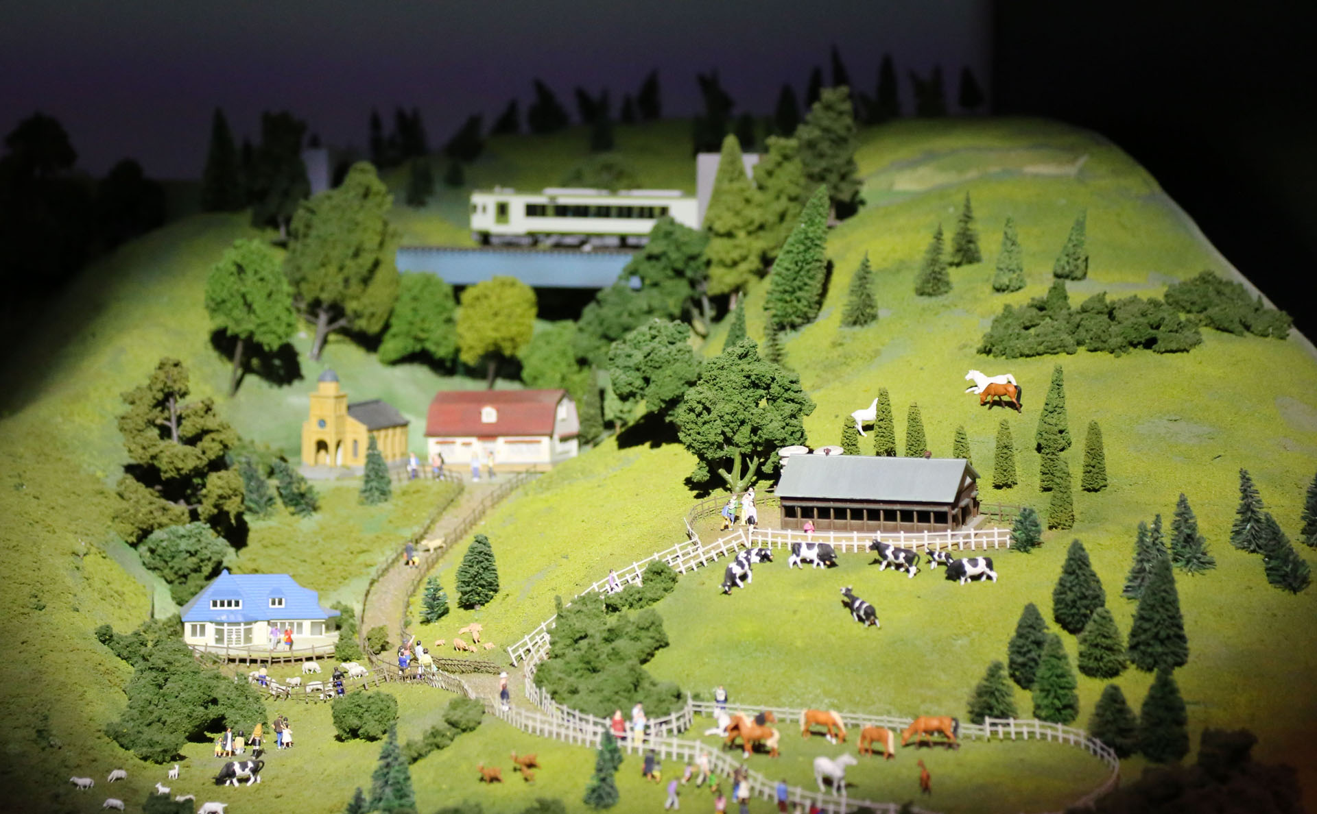 清里の牧場と、その上を走る小海線の車両。登場は一瞬