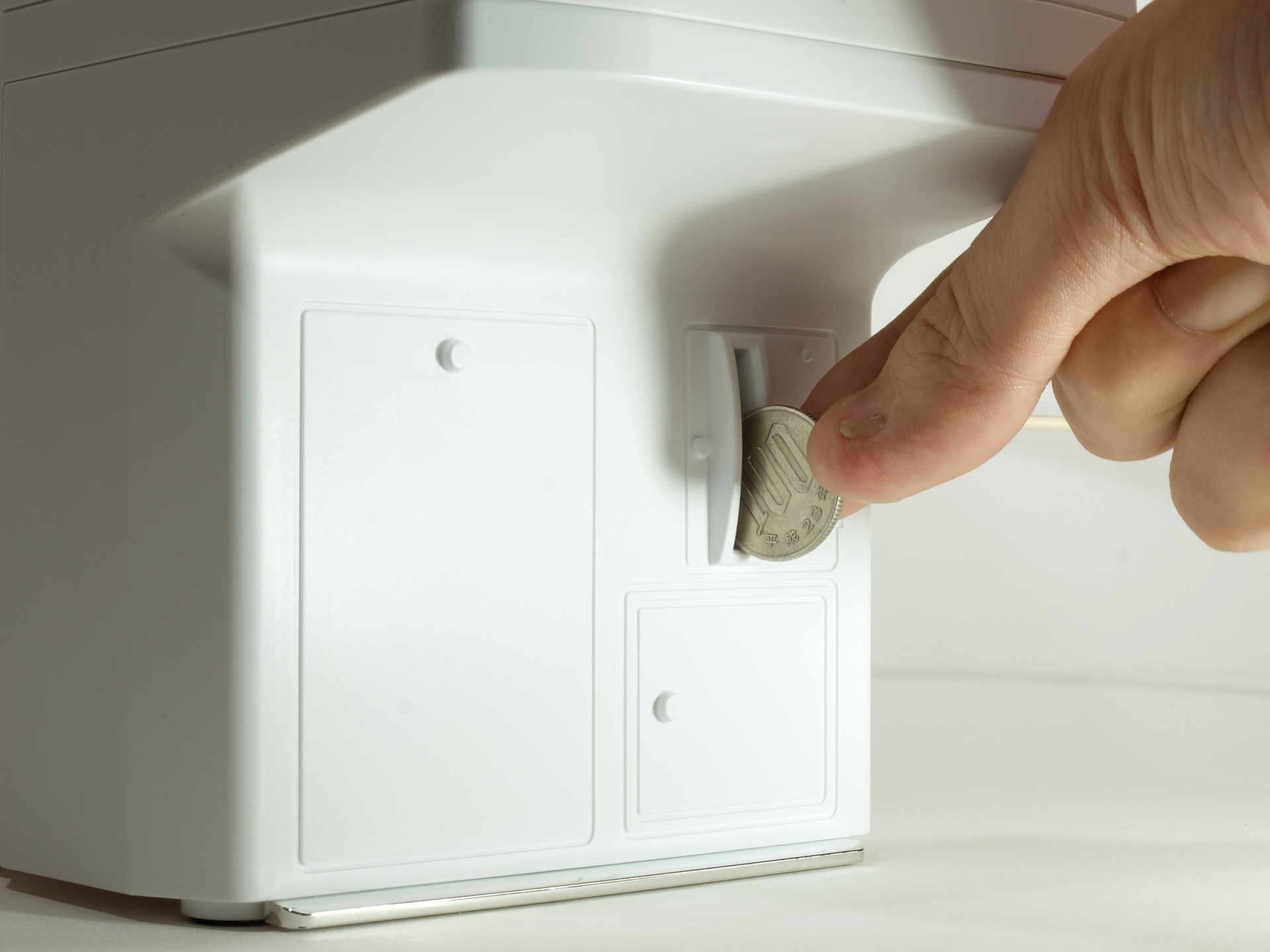 ベース部にはコイン投入口があり、本物の100円玉が投入可能