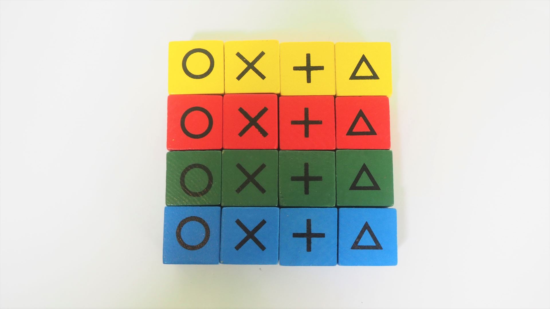 木製のキューブコマ。○×＋△の4種類×4色で合計16個となる