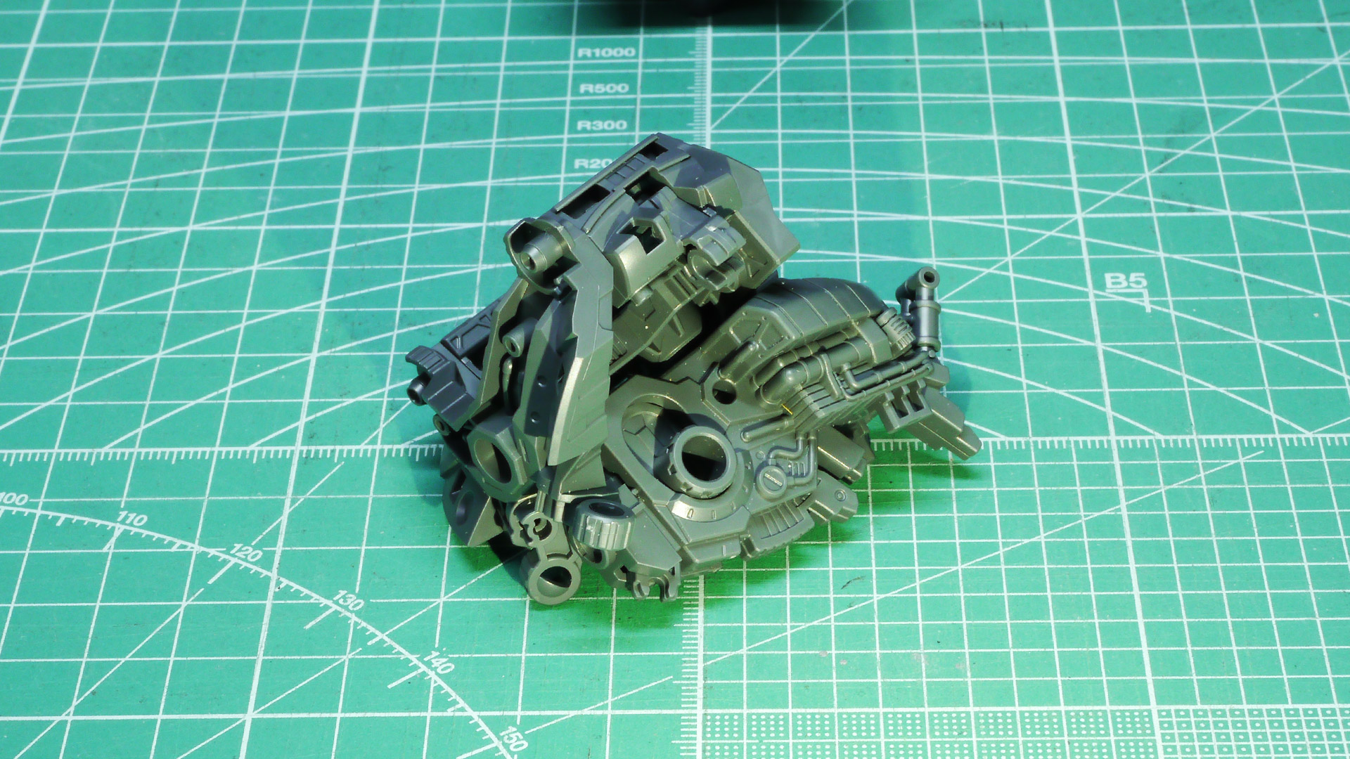 基部の後部のシリンダー状の部分にはケーブルが接続されて油圧か電動のようなデイテールがあります。他にもスプリングやパイプ類のモールドもあり、マシーンとしてのリアリティが増しています