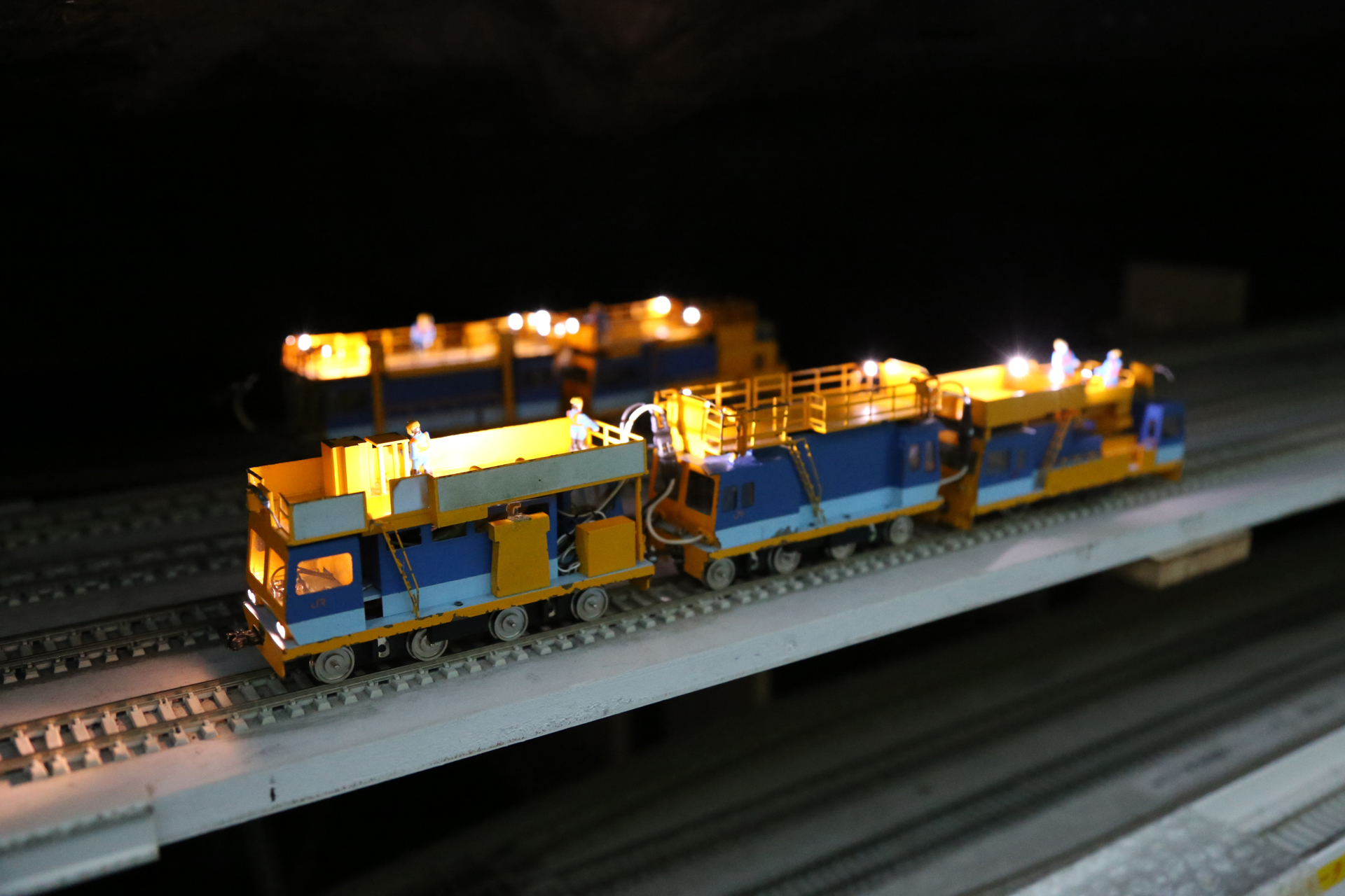 車両基地の面積はもったいないので、FRP製の山の下を全部留置線とした。夜間走行に備えて保守車両が待機中。