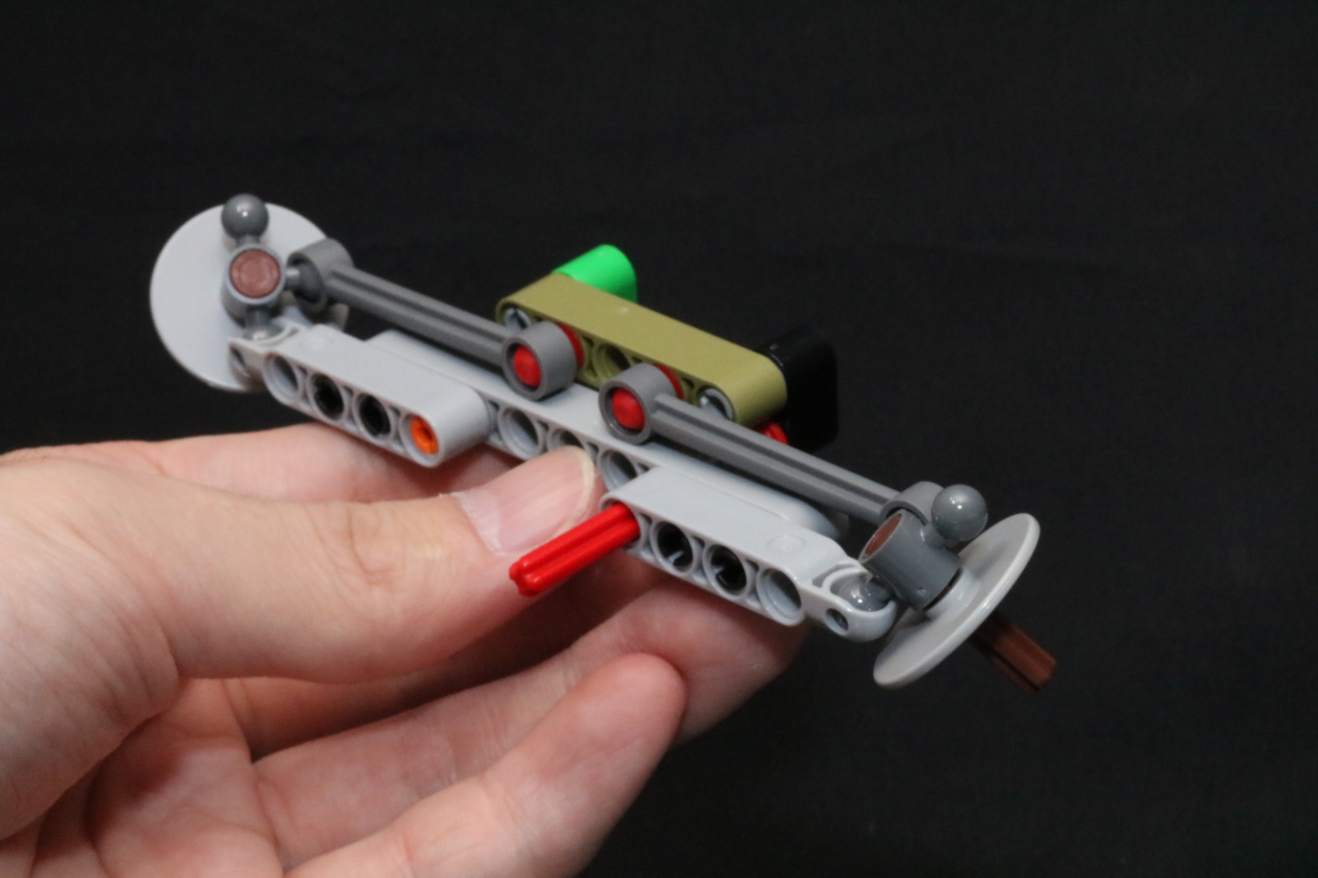 赤い棒状のパーツが軸となっており、これを左右にひねることで各ピースと連動し端のパーツに働きかける