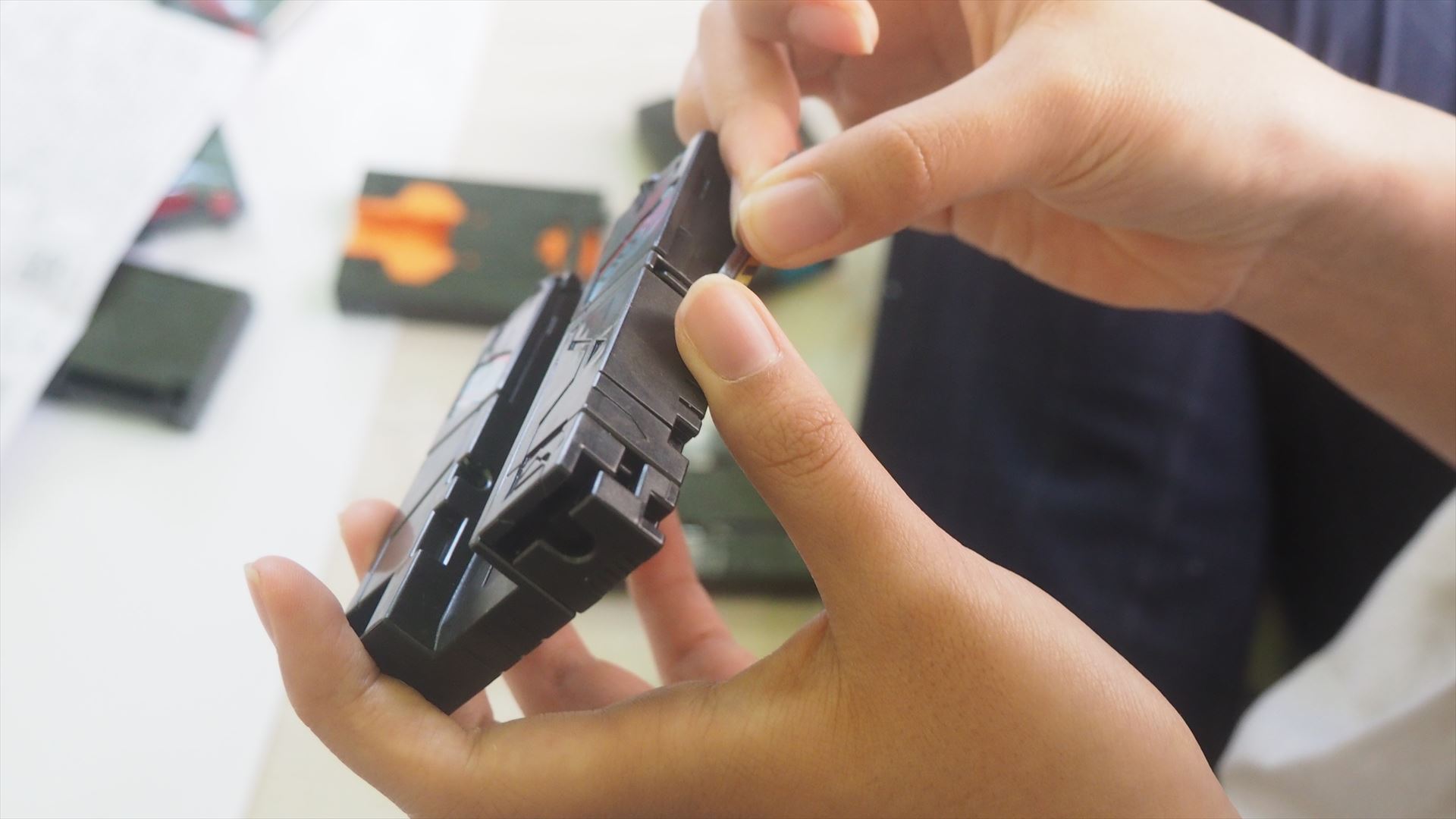 チェインレンサーにステッカーを貼っているところ