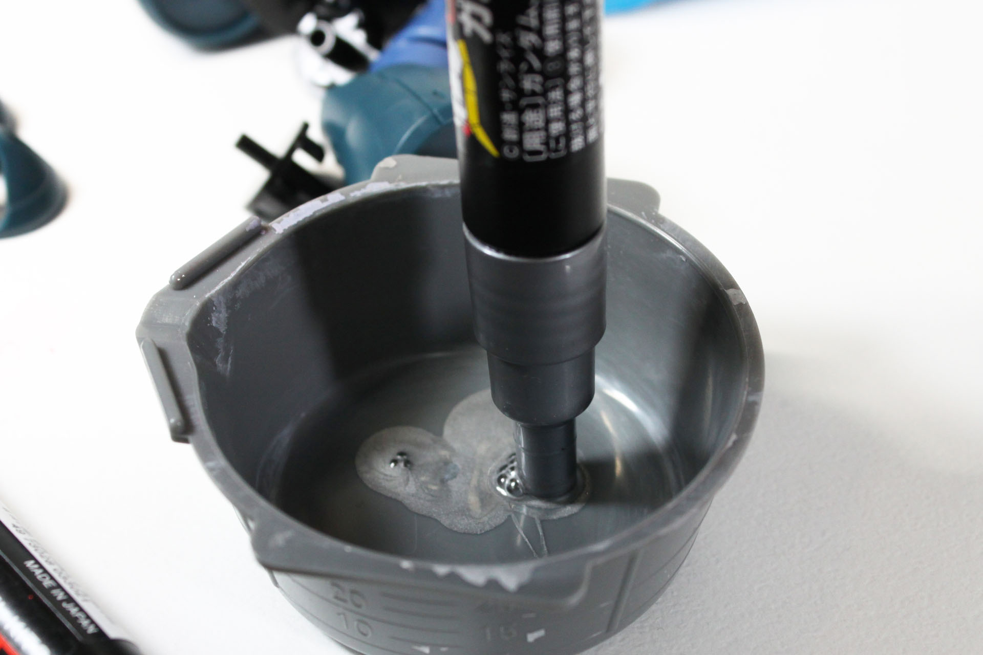 まずはシルバーのガンダムマーカーのペン先をお皿に押し付けて、塗料を出します。写真では模型専用の皿を使っていますが、周りが汚れなければなんでもけっこう