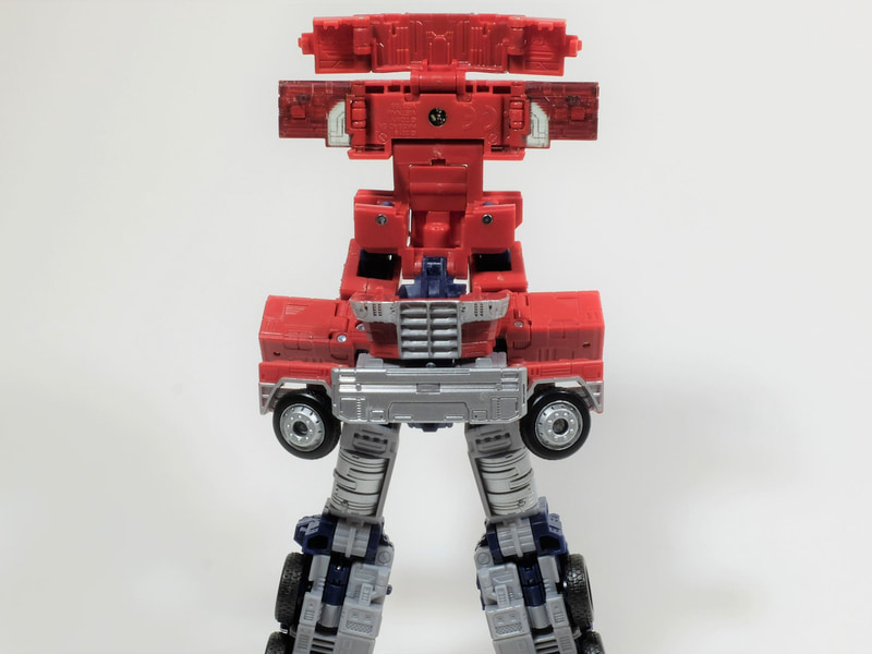 次にコンボイの胸部と腰部のロックを外して展開する。ここは個体差があり、物によってはかなりガッチリとハマっている場合もあるので力加減をうまく調整しながら展開する。うまくロックが外れたら、2段階に折り畳まれたトラクターヘッドのフロント部を展開。この時トラクターヘッドのフロント下部を開いた際にフロント上部とロックできるので、カチッとハマるまで開く。そしてフロント部の背面に畳まれた扉をすべて全開にする。