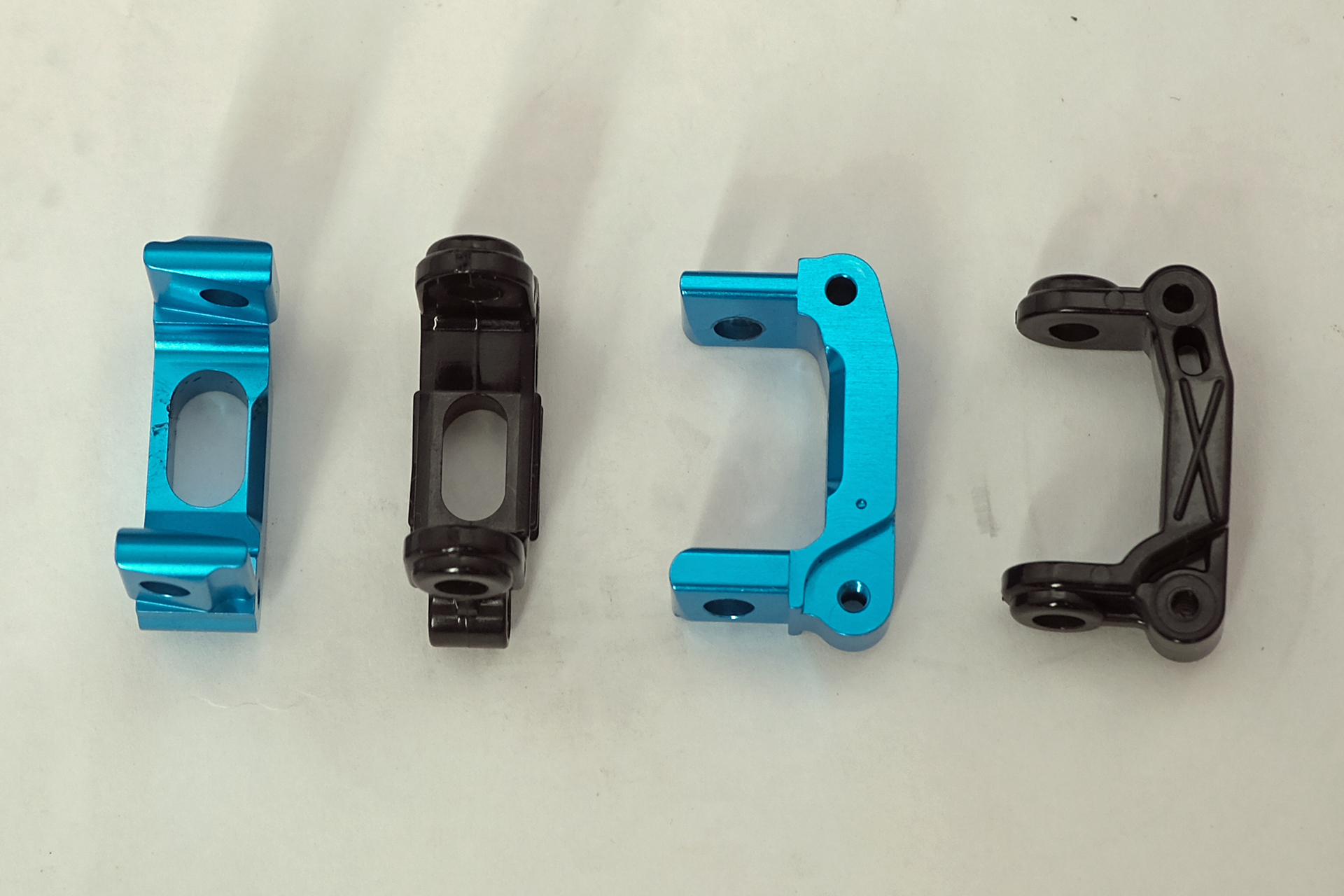 黒い樹脂製のノーマルハブキャリアとの比較。ノーマルは左右同じ物だが、アルミハブキャリアは8度のキャスター角が付いていて左右別のパーツになっている