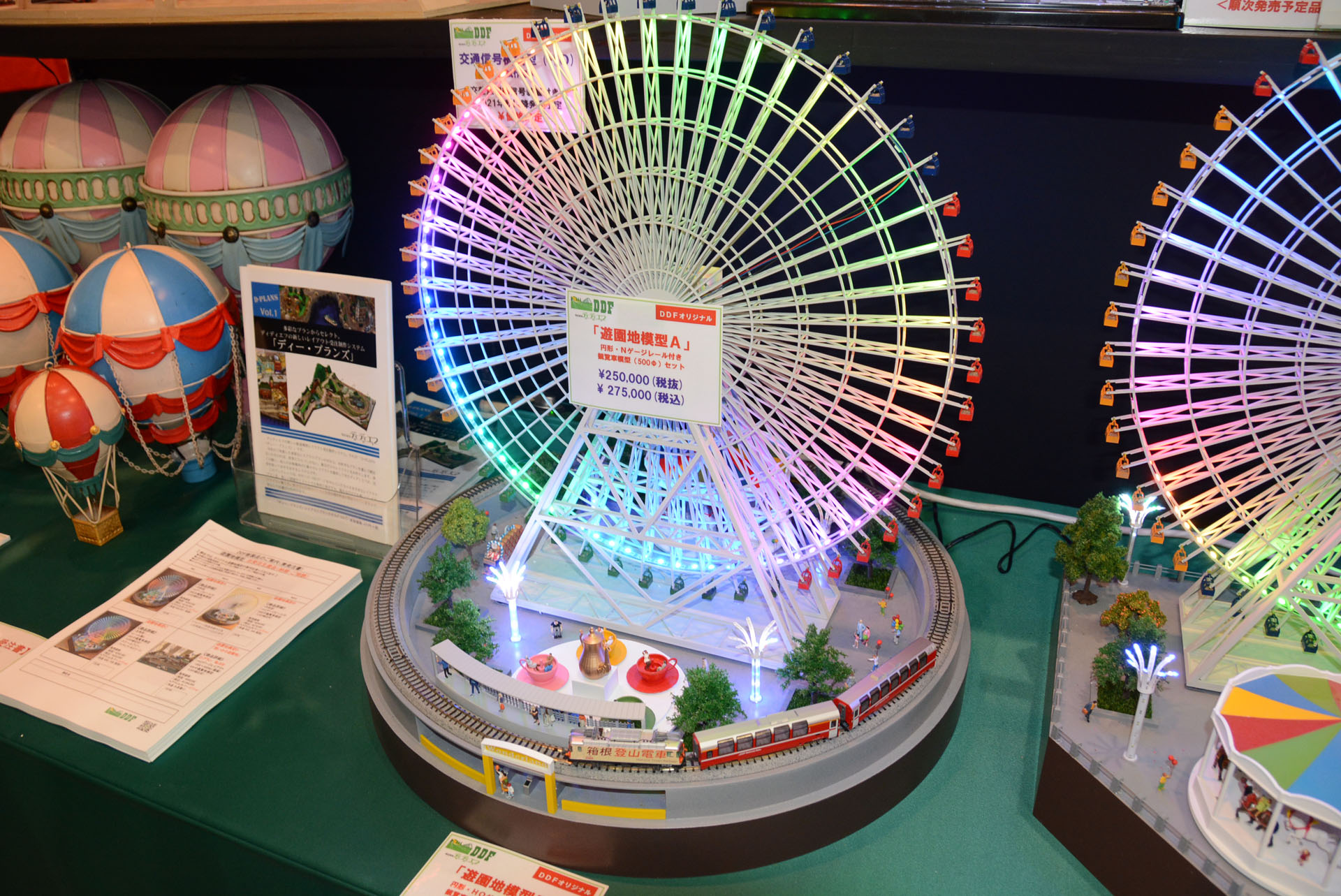 大きな観覧車の周りを鉄道が巡るジオラマ。奥のメリーゴーランドも動く。27万5千円(税込)で製作できるという