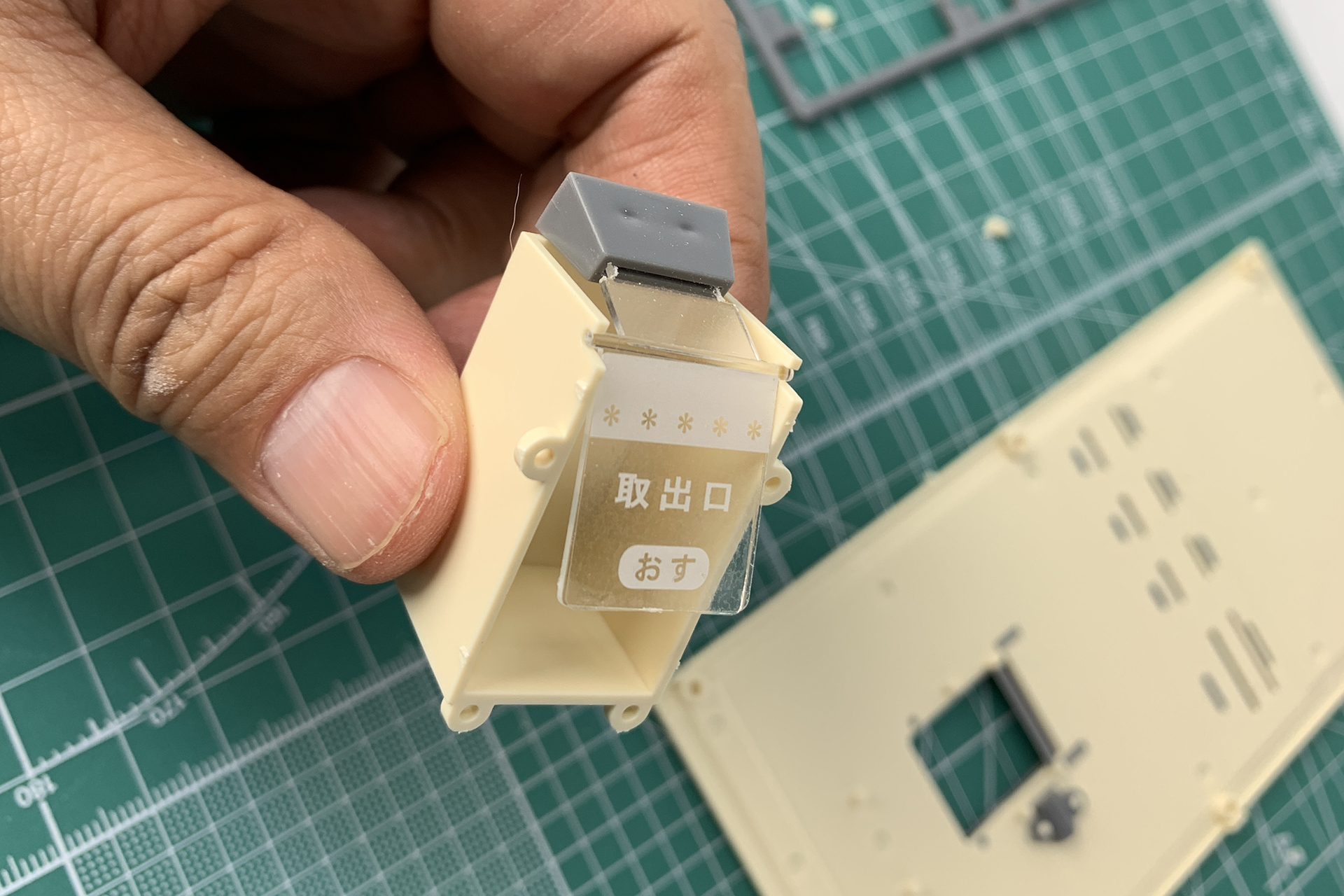 これが取り出し口部分。前面パネルの背面側に取り付けます。グレーのパーツが重り代わりになって、開閉するという仕組みですね