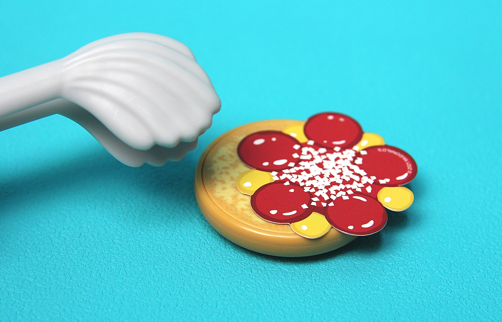 マスタードやケチャップ、オニオンが描かれた台紙を乗せて…