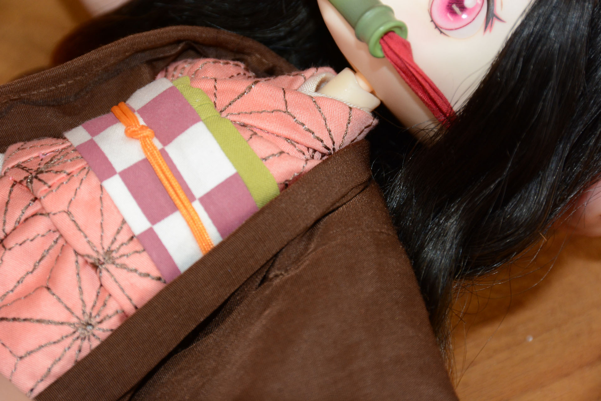 首元のしっかりした重ね着表現は芯に樹脂を使うことで可能に。服の柄は刺繍で表現されている