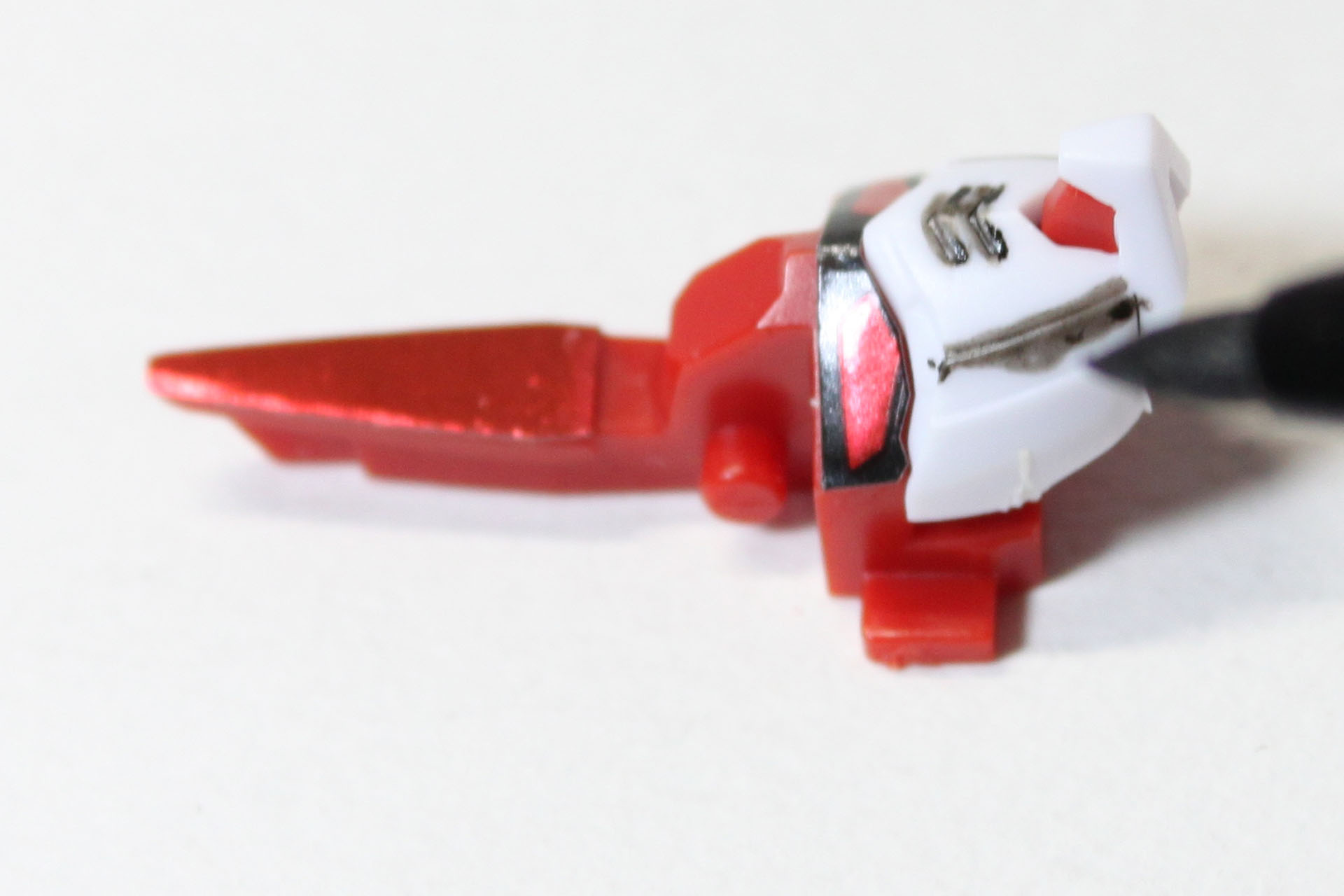 顔面にスミ入れ中。こちらはなんとなーく、ですが、紫ではなく黒のほうが締まって見えると思い、スミ入れペンを使いました。なんとなーく、と言いましたが、小さい箇所ですから、強い色のほうが映えるかな？　という判断ではあります。こういうことを考えるのが、また楽しいわけです