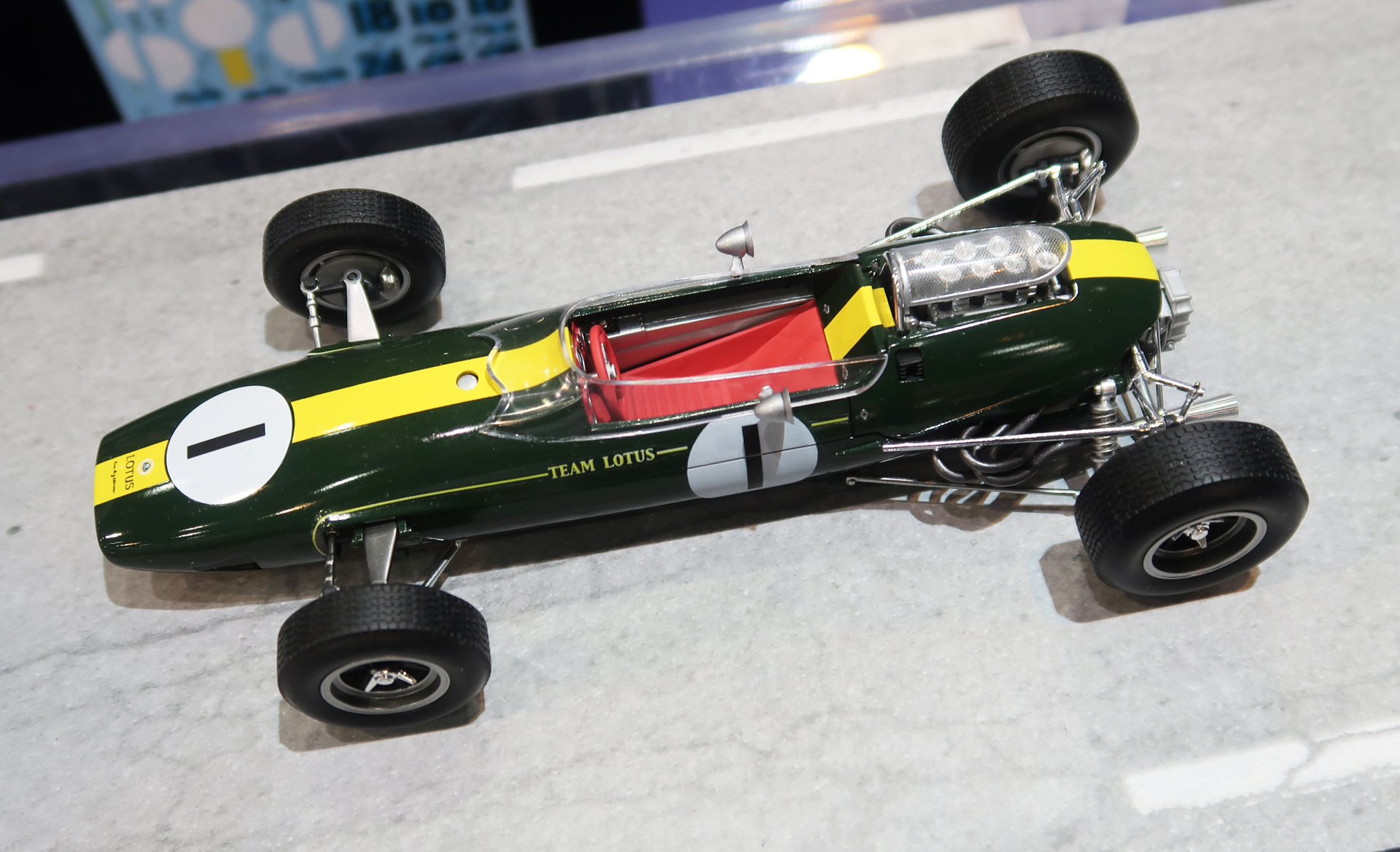 「第59回静岡ホビーショー」のエブロブースにて初公開された、「1/20 Team Lotus Type33 1965 Formula One Champion COVENTRY CLIMAX FWMV（ロータス33）」。まだスポンサーカラーが用いられる以前のマシンのため、ボディはイギリスのナショナルカラーであったディープグリーンに塗装され、そこにイエローのストライプ、赤いシート＆ステアリングホイールがアクセントカラーになっている。なお、シートベルトが装着されていないことに「……？」となった人もいるかと思うが、これは別にエブロが手を抜いるわけではなく、この時代のF1マシンにはシートベルトが装着されていなかったのだ（！）