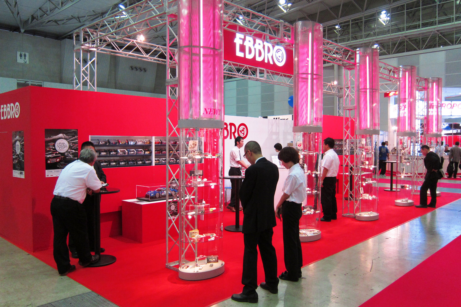 「第51回 全日本模型ホビーショー」会場におけるエブロブース。透明の支柱5本の中にこの会場で発表されたダイキャスト製ミニチュアカーの新製品が展示されていたが、この1本の支柱内に、前述した「Something else 2012」のパネルがこっそりと展示されていた