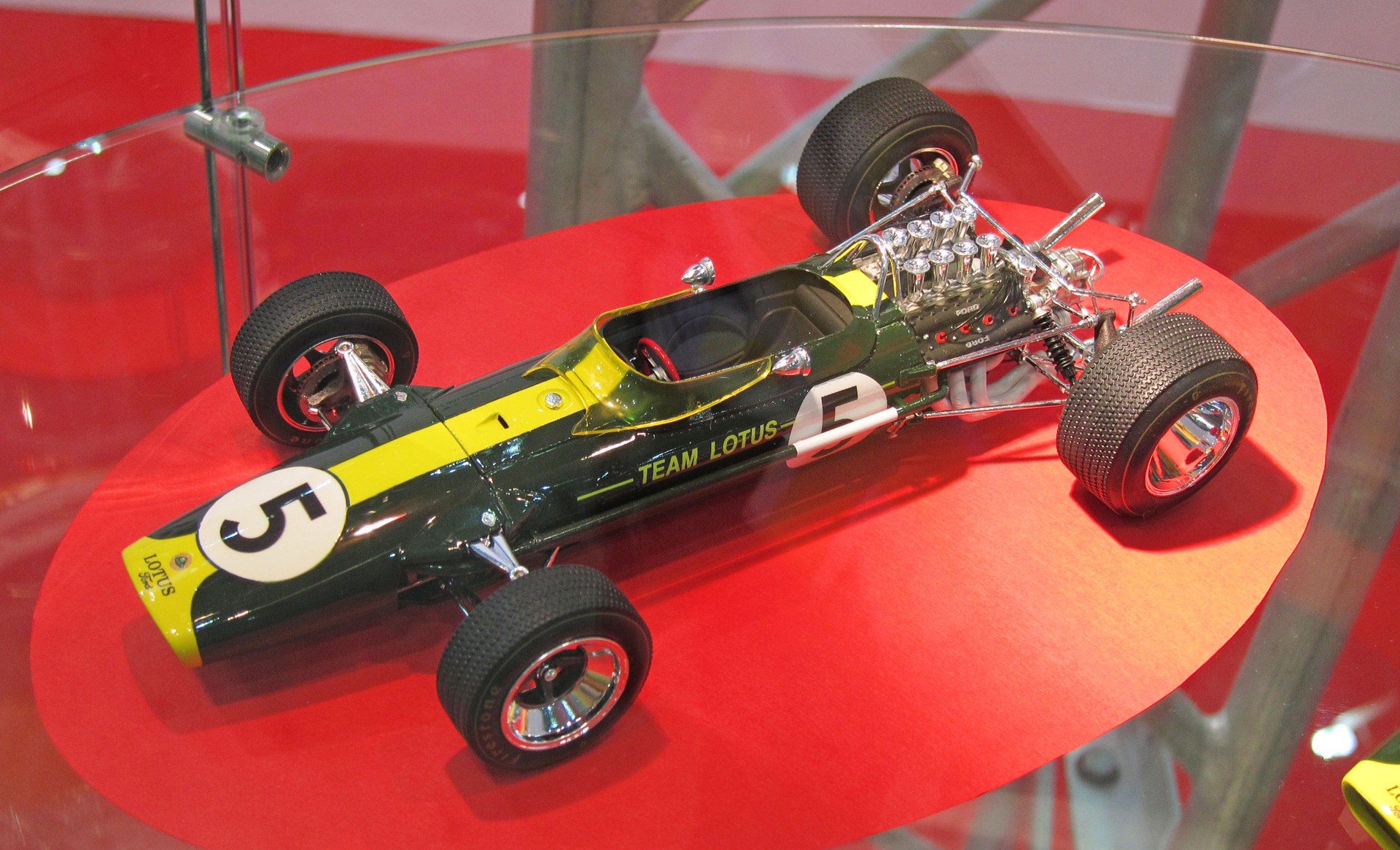 2012年10月開催の「第52回全日本模型ホビーショー」にて展示発表された、1/20 Team Lotus Type 49 1967(ロータス49)。名機フォード コスワース DFVエンジンを最初に搭載したF1マシンで、1967年から1970年まで使用され通算12勝を獲得した名車中の名車だ(ジム・クラーク5勝、グラハム・ヒル4勝、ヨッヘン・リント2勝、ジョー・シフェール1勝)。ロータス72系のあとにエブロがこのマシンをプラスチックモデル化したのは当然と言えば当然であり、ロータス72系と同様に、1/20スケールキットとして考えるとその精密再現はある意味狂気の世界であった。ちなみにこのころになるとホビーショーのエブロブースにおける透明の支柱4本のうち1本は1/20 F1プラスチックモデル展示にあてがわれるようになっており(画像のいちばん右側の支柱がそれに相当する)、「1/43 ダイキャスト製ミニチュアカーと1/20 F1プラスチックモデルの開発が等価になりつつあった様子」が伺える