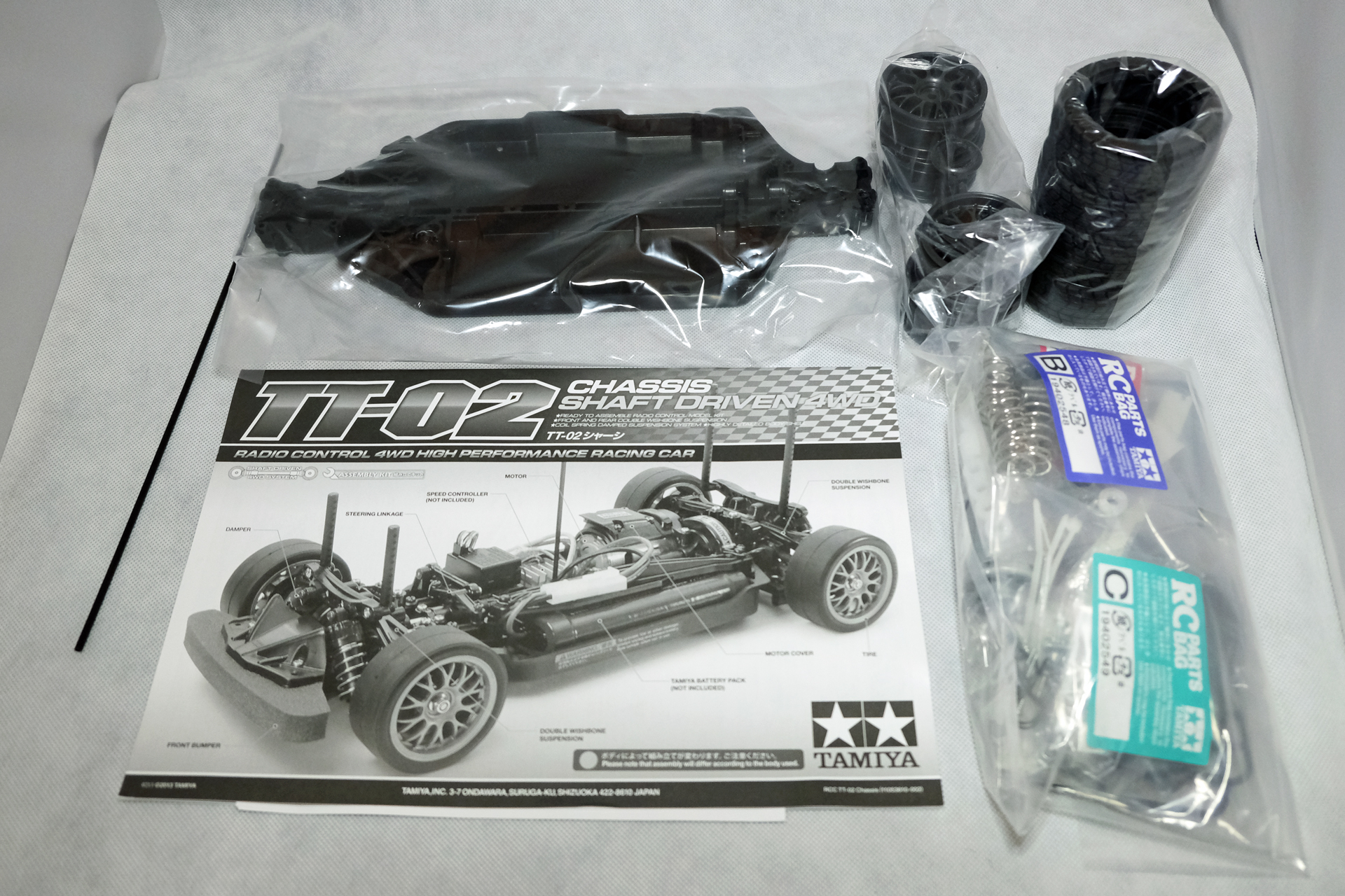 「TT-02シャーシ」は、「バスタブ」型のフレームが大きな特徴だ。タイヤや金属部品はそれぞれパッケージに収められている