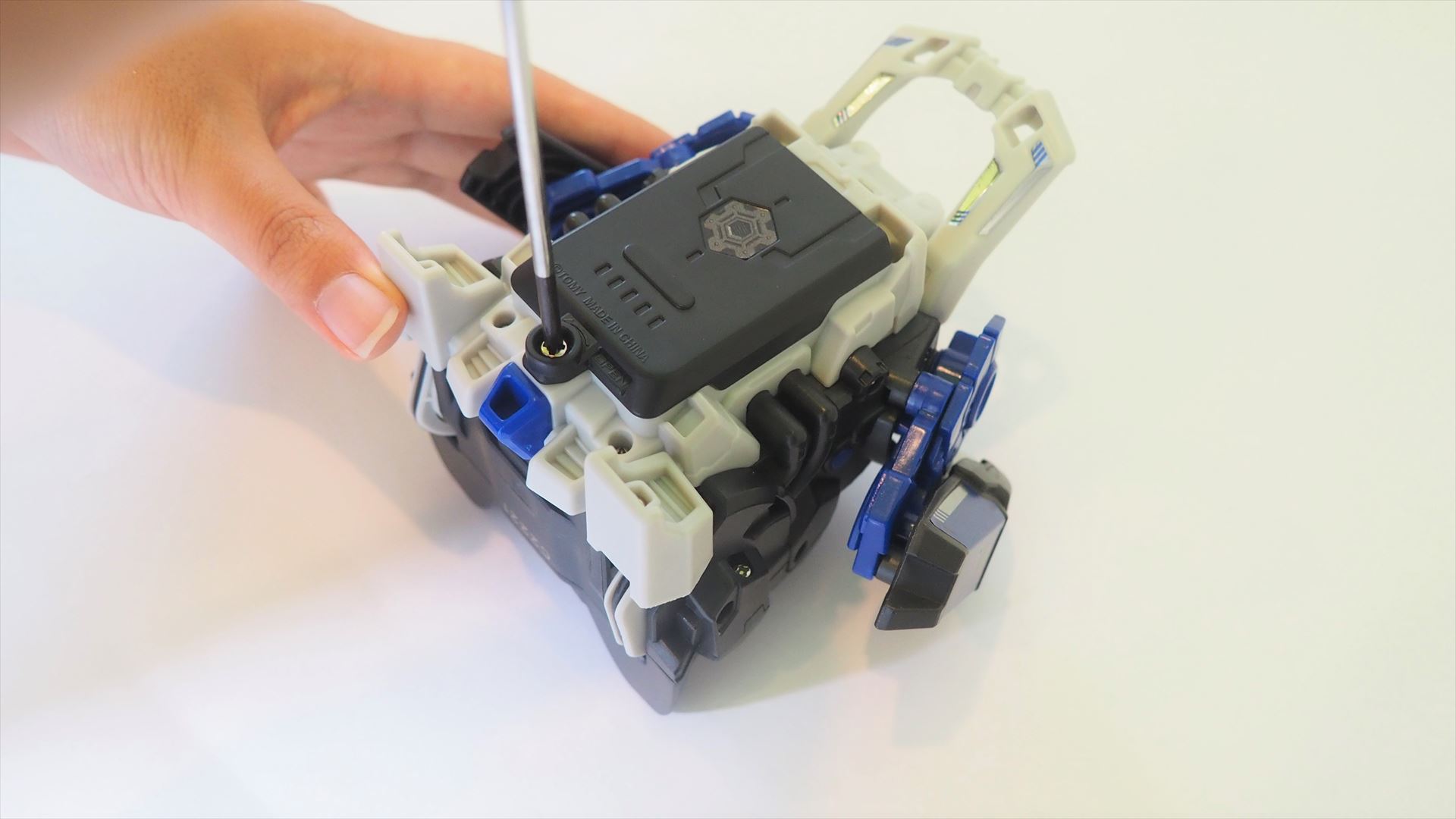 ドライバーを使って本体背面の電池ブタのネジを外す