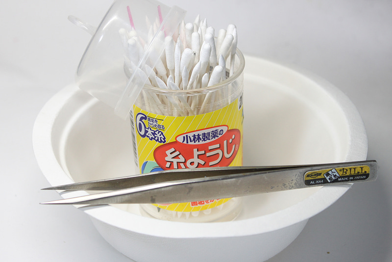 今回使用した道具。水を入れるお皿に、ピンセット、そして綿棒です。なお綿棒は、細いタイプと太いタイプの両方を、取り出しやすいようにカップ状の入れ物に入れて保管しています。いまのところ、糸ようじの入れ物が便利ですね