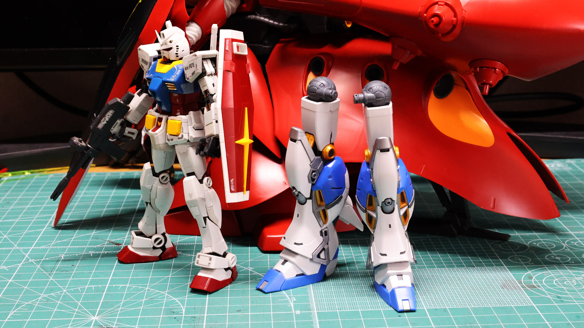 同スケールの「RG 1/144 RX-78-2 ガンダム」（写真左）と比較すると、脚部の時点でだいぶ巨大です。ライバル機「HG 1/144 ナイチンゲール」（写真奥）の巨体と並べても遜色はなさそうです