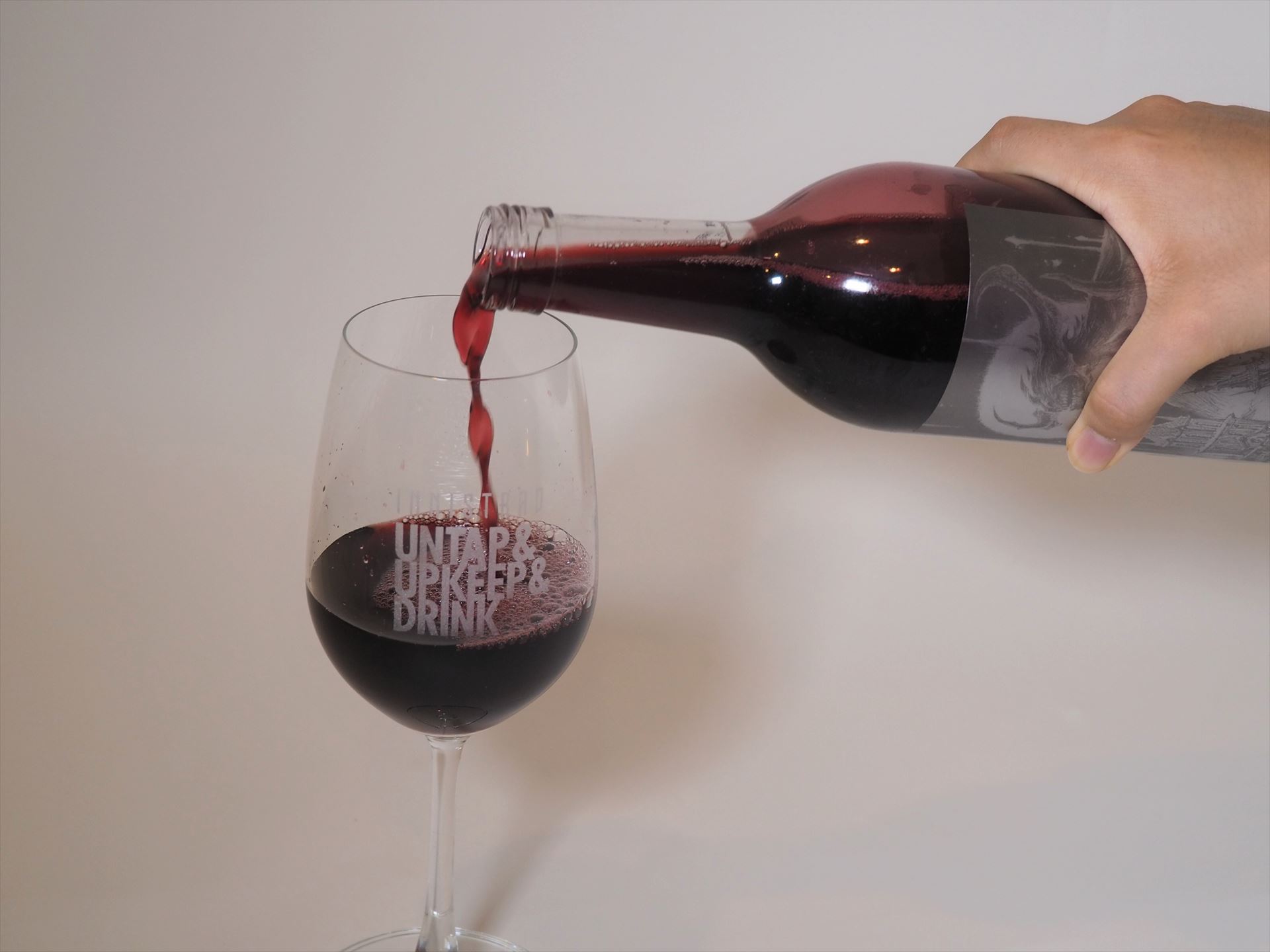 ぶどうジュースをワイングラスに注いでいる様子