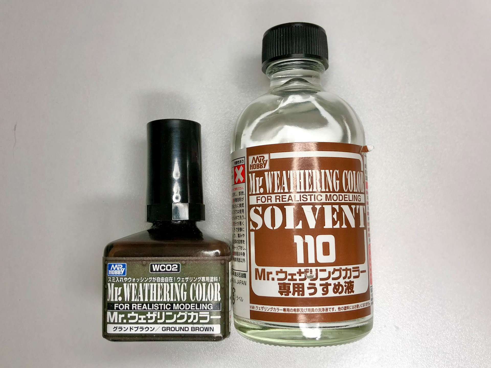 ウォッシングで使用するクレオスの「Mr.ウェザリングカラー　グランドブラウン」と専用の薄め液。模型店などで見かけることも多いと思います。