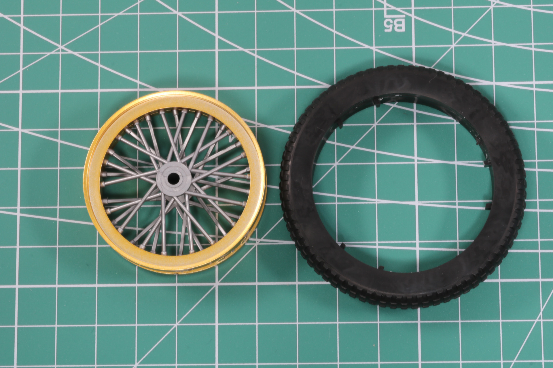 パーツを合わせることで厚みとスポークの重なりを演出。そして、太めの軟質パーツで覆う