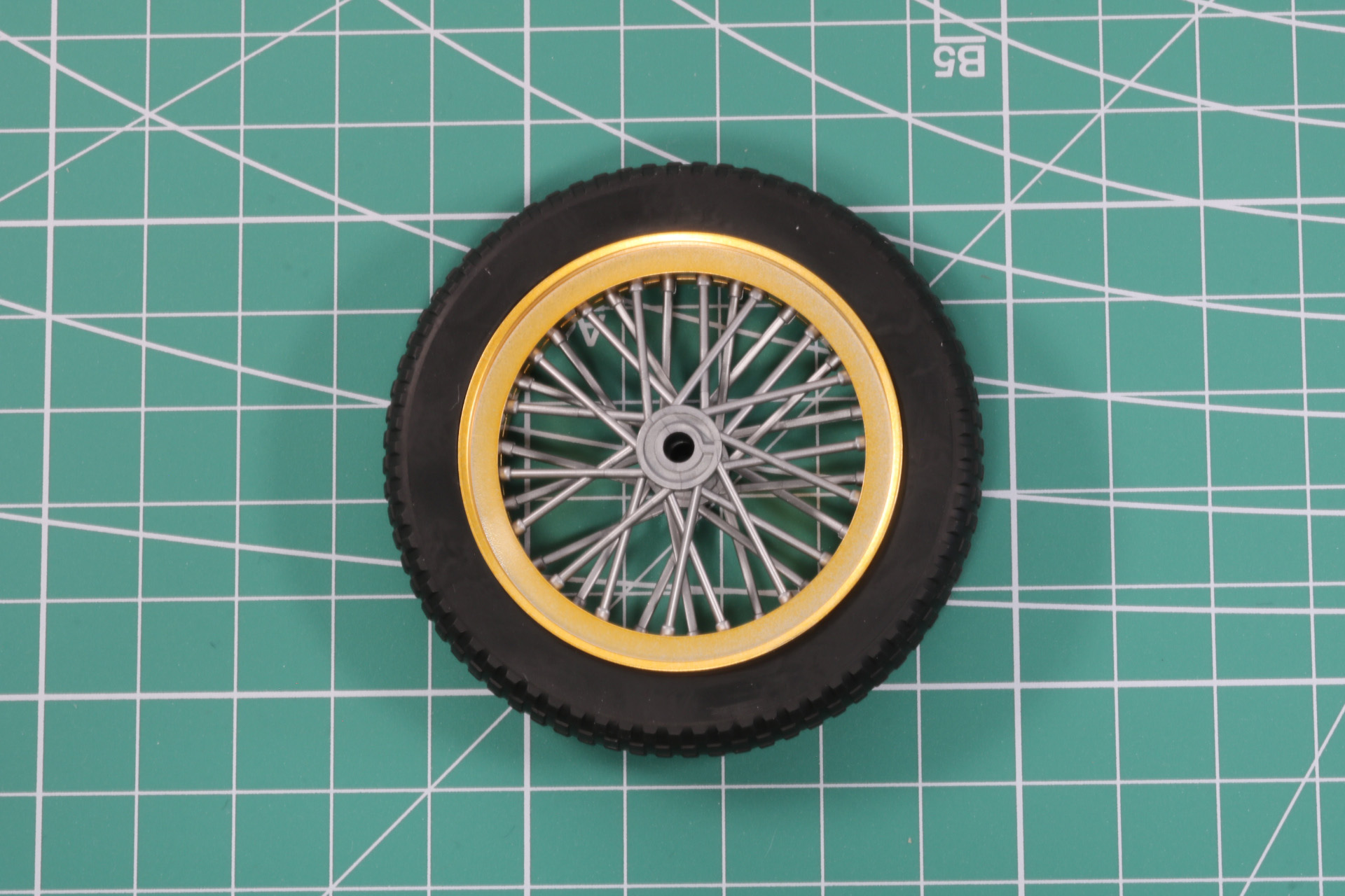 パーツを合わせることで厚みとスポークの重なりを演出。そして、太めの軟質パーツで覆う