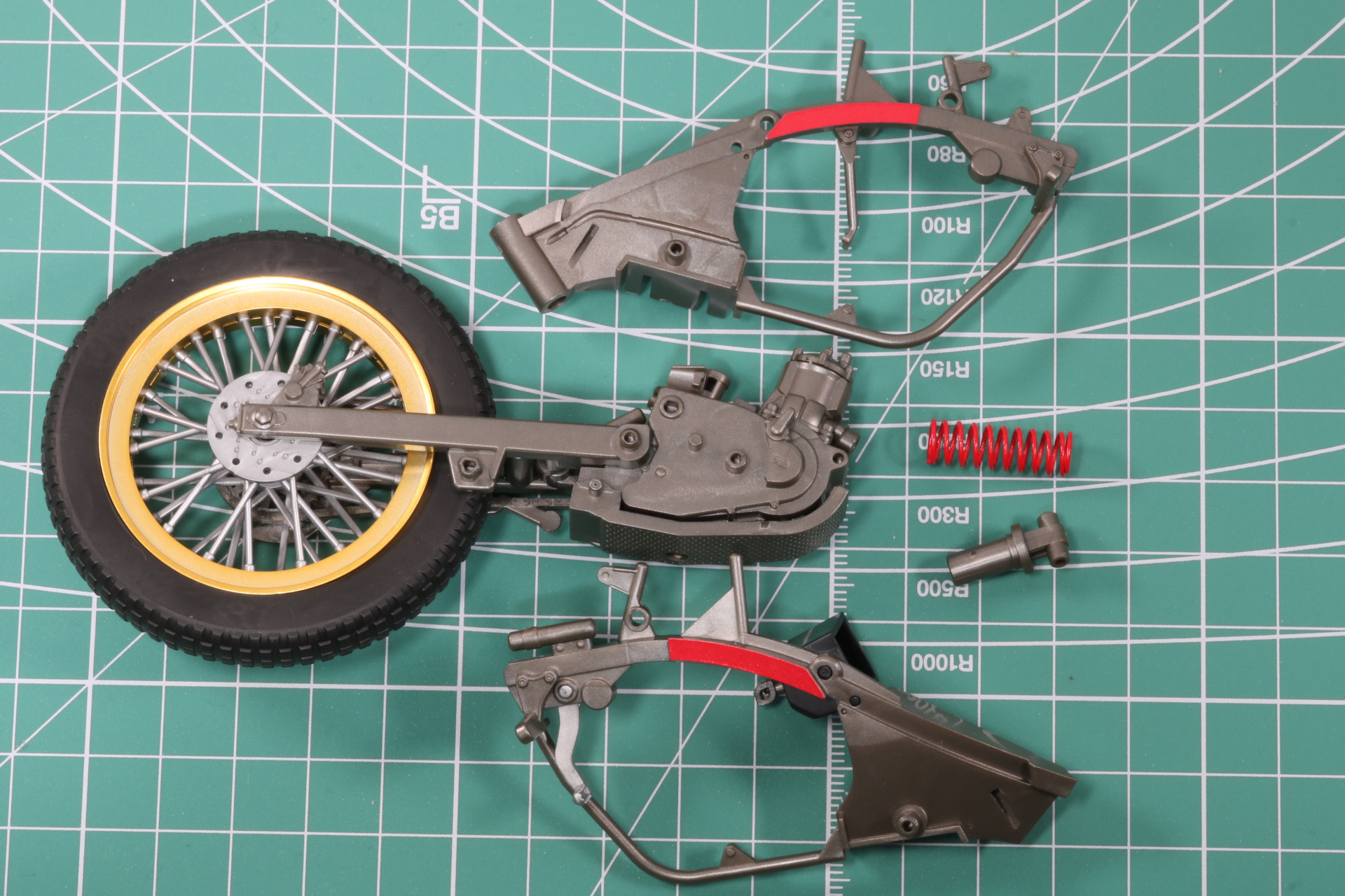 両サイドのフレームでエンジンとスプリングの軸パーツを挟み込む