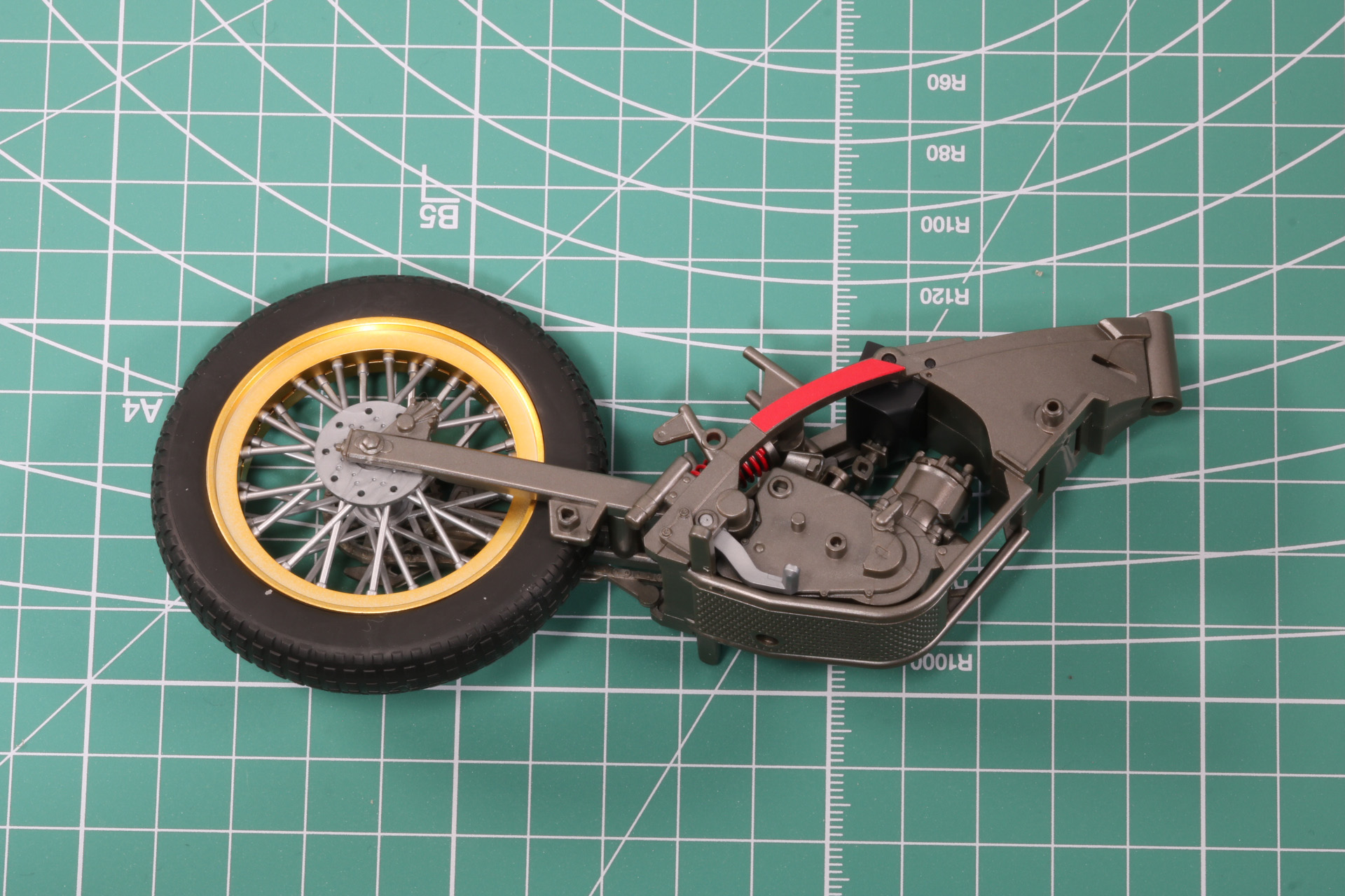 両サイドのフレームでエンジンとスプリングの軸パーツを挟み込む