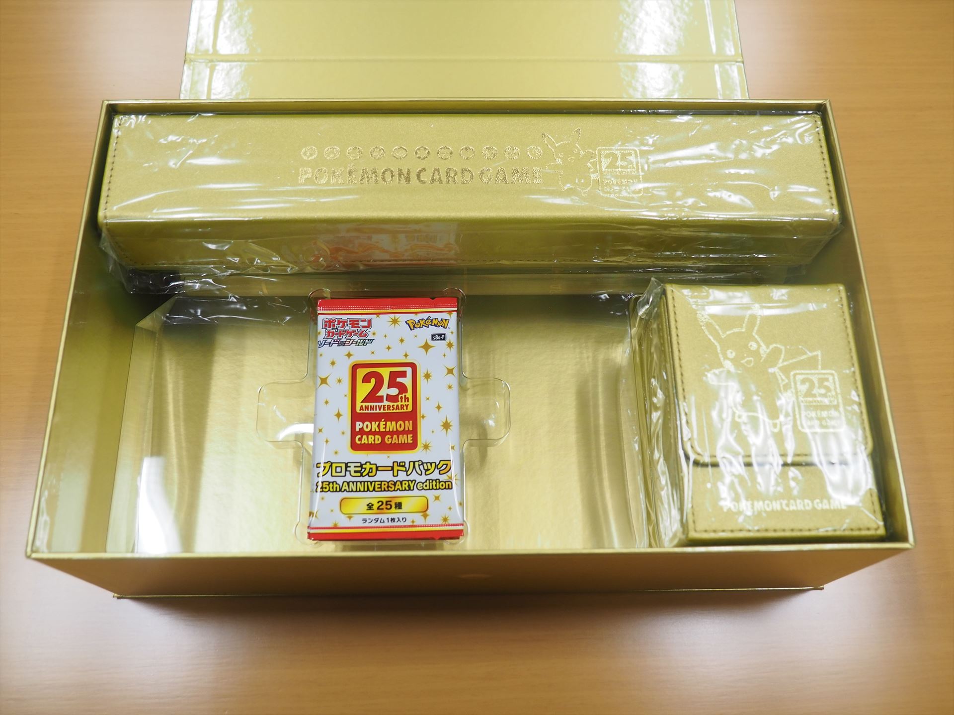 デッキシールドと金属製ダメカンサイコロ、合皮製ダメカンケースが収納されていた透明トレイを取り出すと、その下にはプロモカードパック 25th ANNIVERSARY editionが5パック入っている