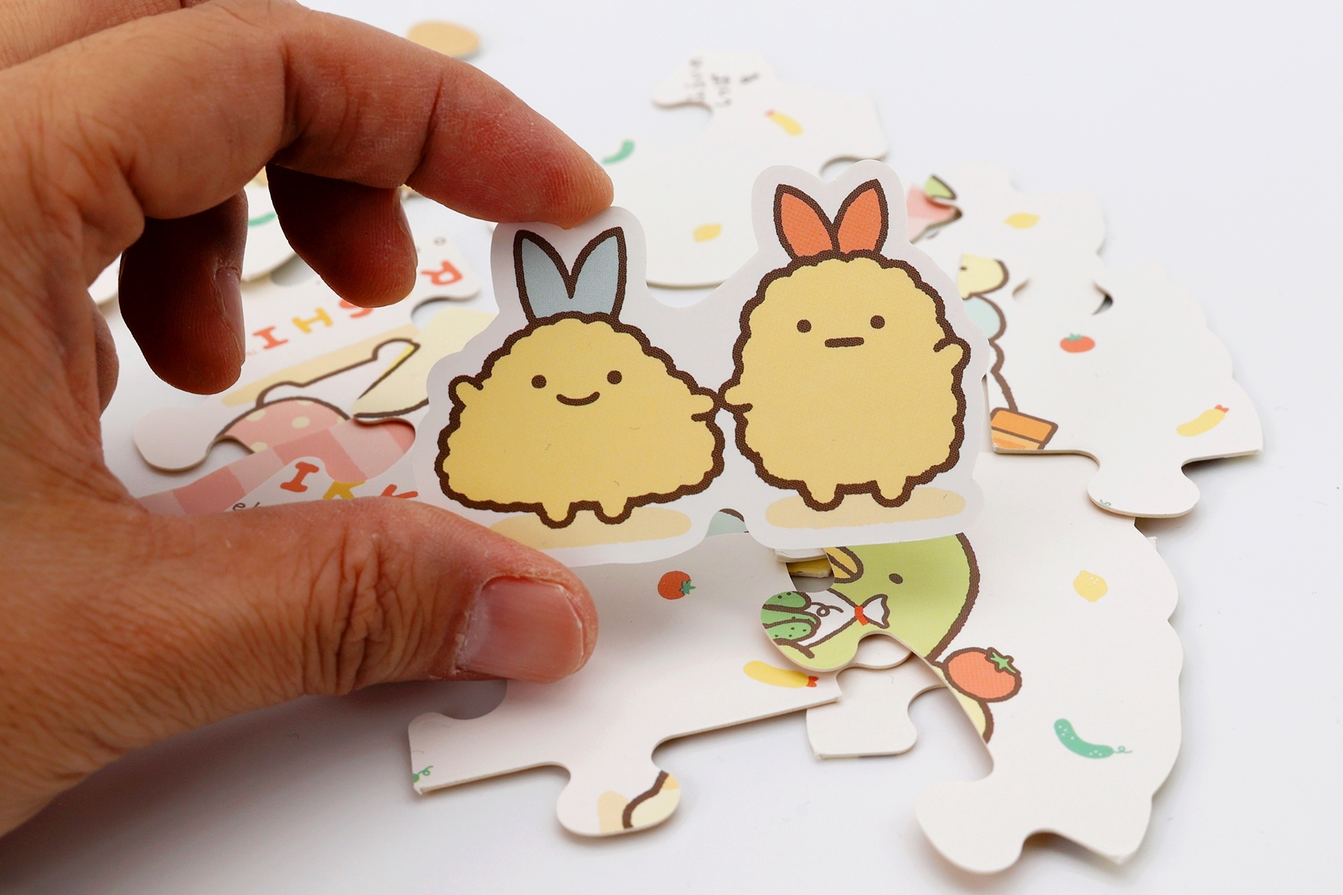 パズル裏面の特殊な形をしたピースは、物語でお使いに出かけたえびふらいのしっぽとあじふらいのしっぽがモチーフになっている