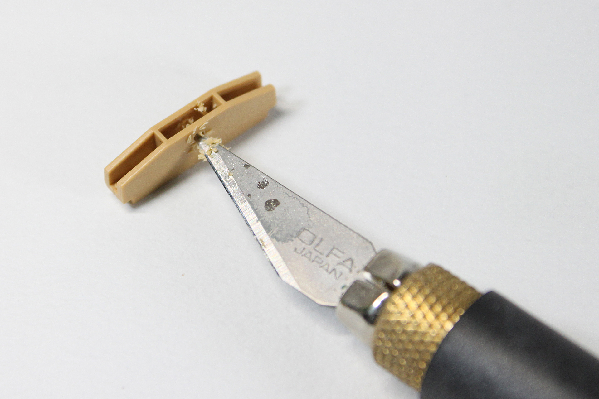 デザインナイフを使って穴を広げています。なるべくきれいにはなるように、ちょっと削っては現物が通るか確認しながら作業しました。多少使い勝手は違うと思いますが、カッターでも同じような作業ができるでしょう